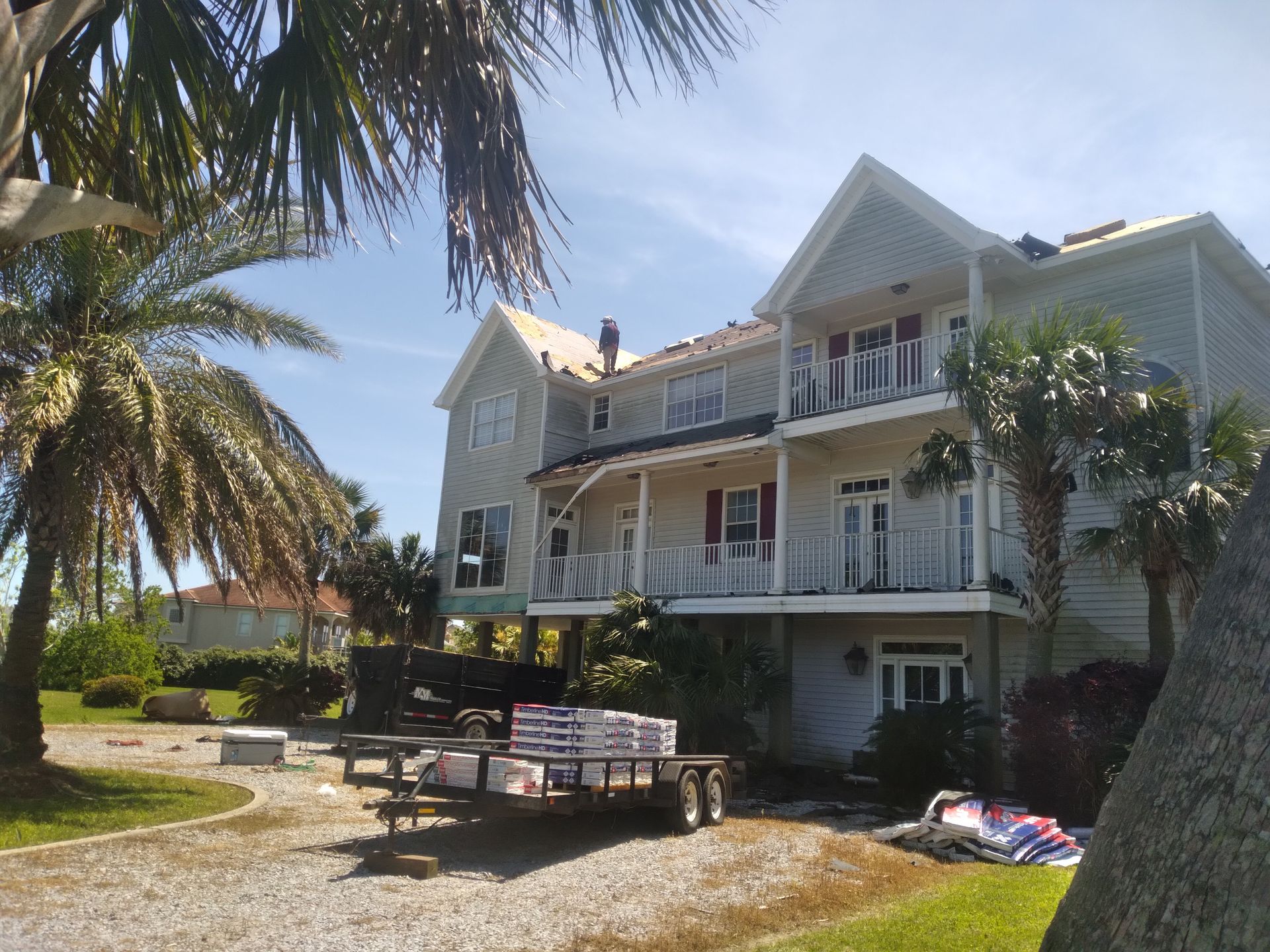 A large white house with a trailer parked in front of it.