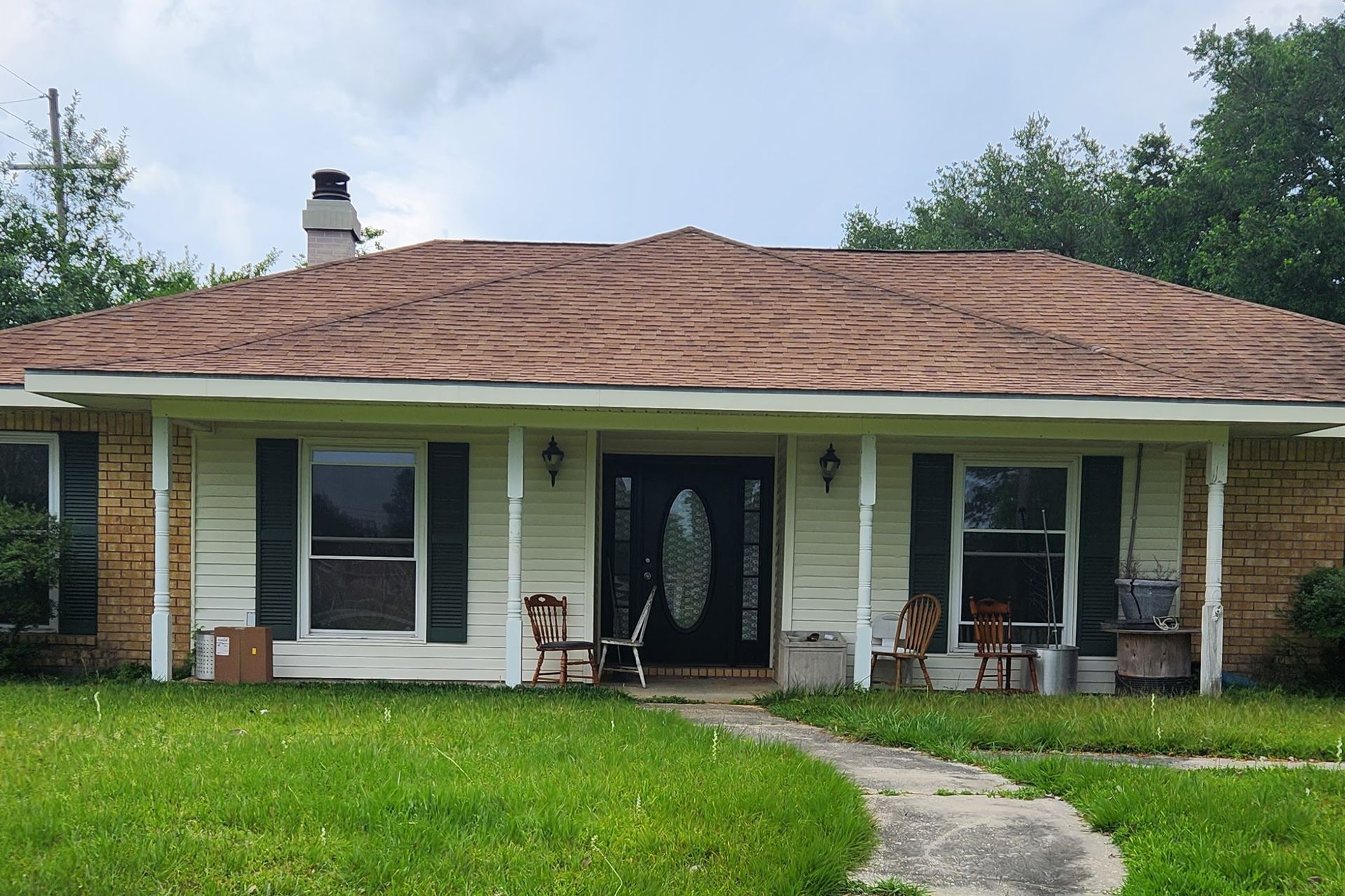 A house with a porch and rocking chairs in front of it