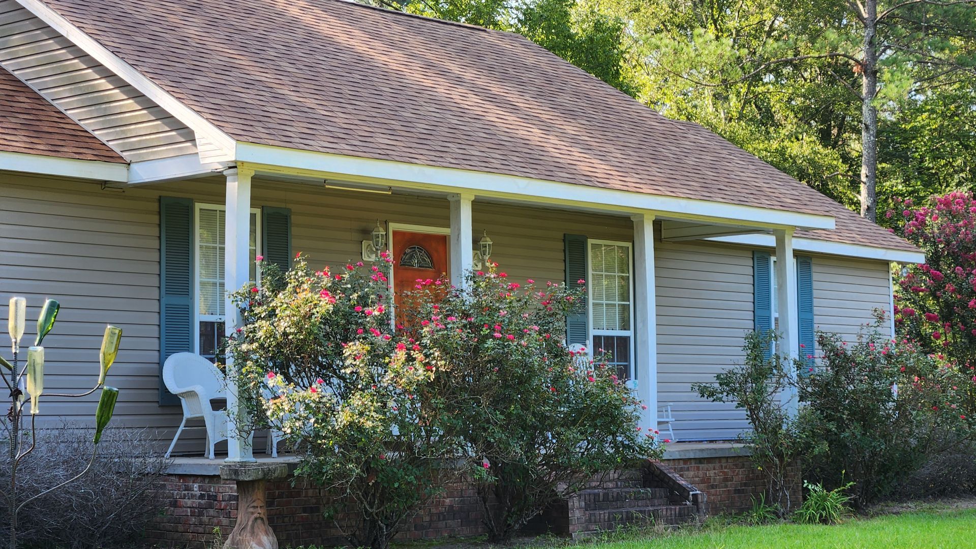 A house with a porch and flowers in front of it