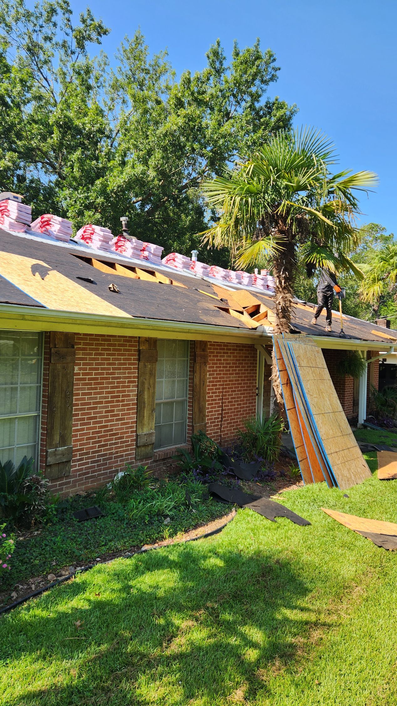 A man is working on the roof of a house.