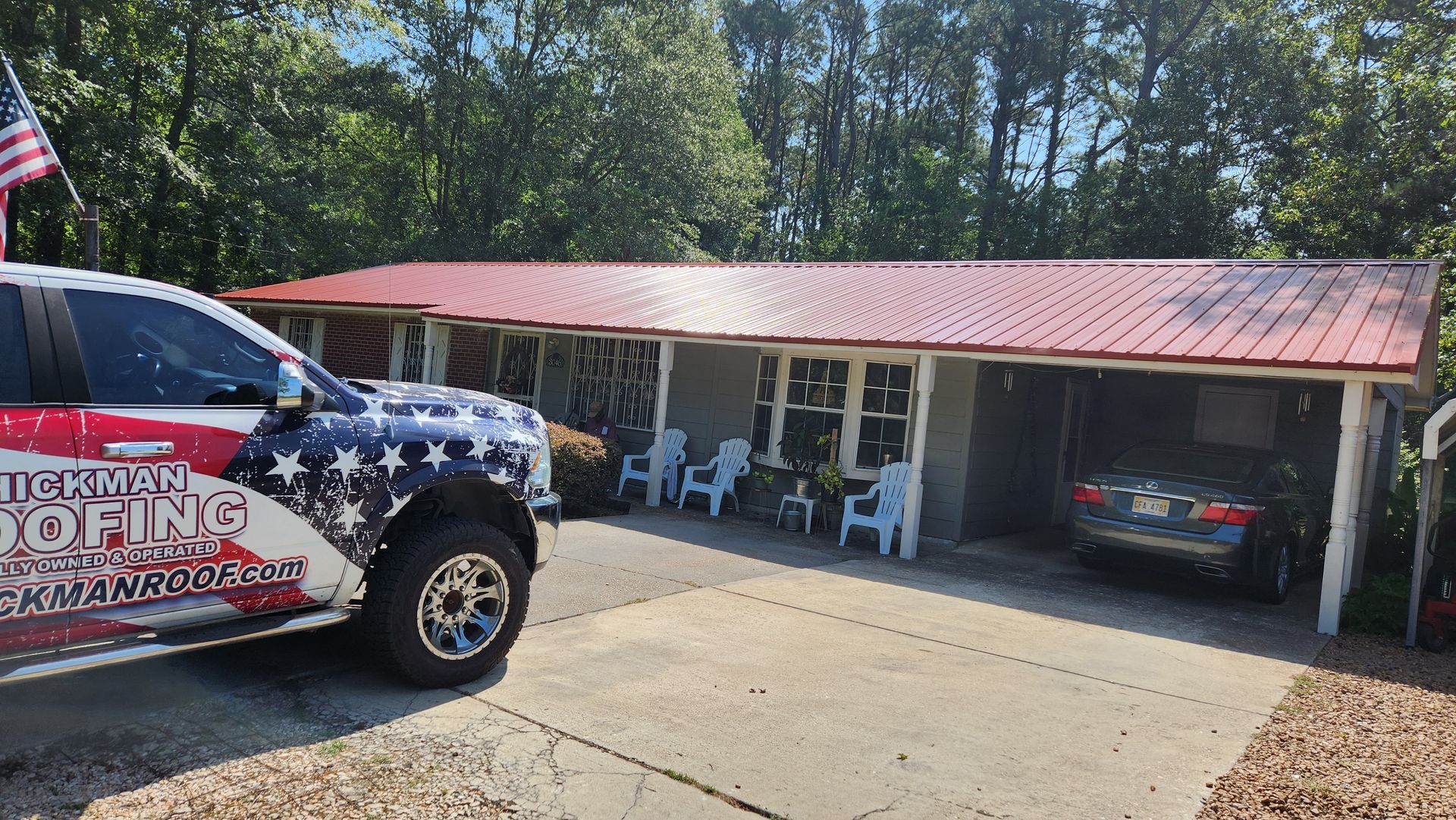 A truck is parked in front of a house with a red roof.