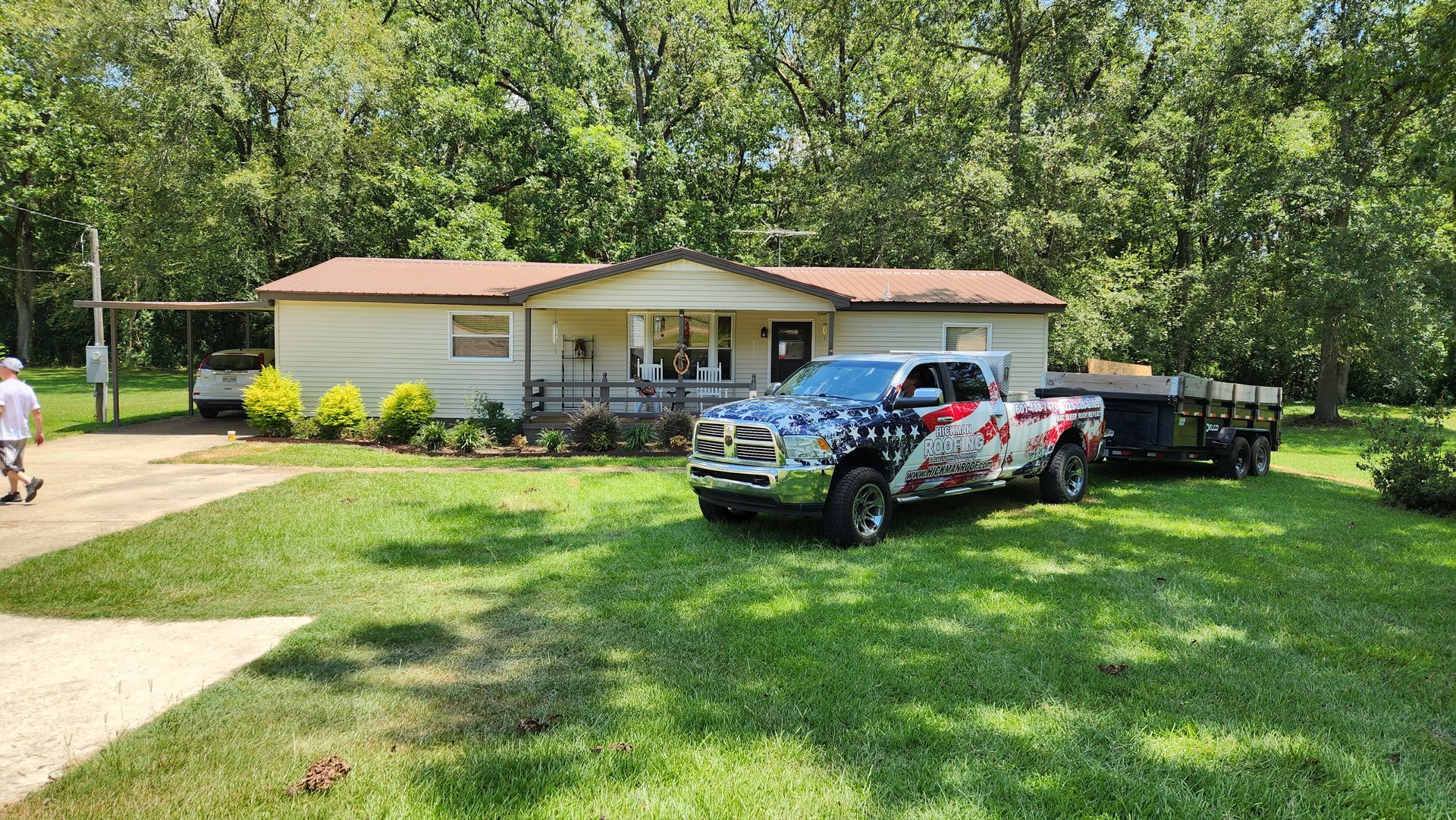 A truck is parked in front of a house with a trailer attached to it.
