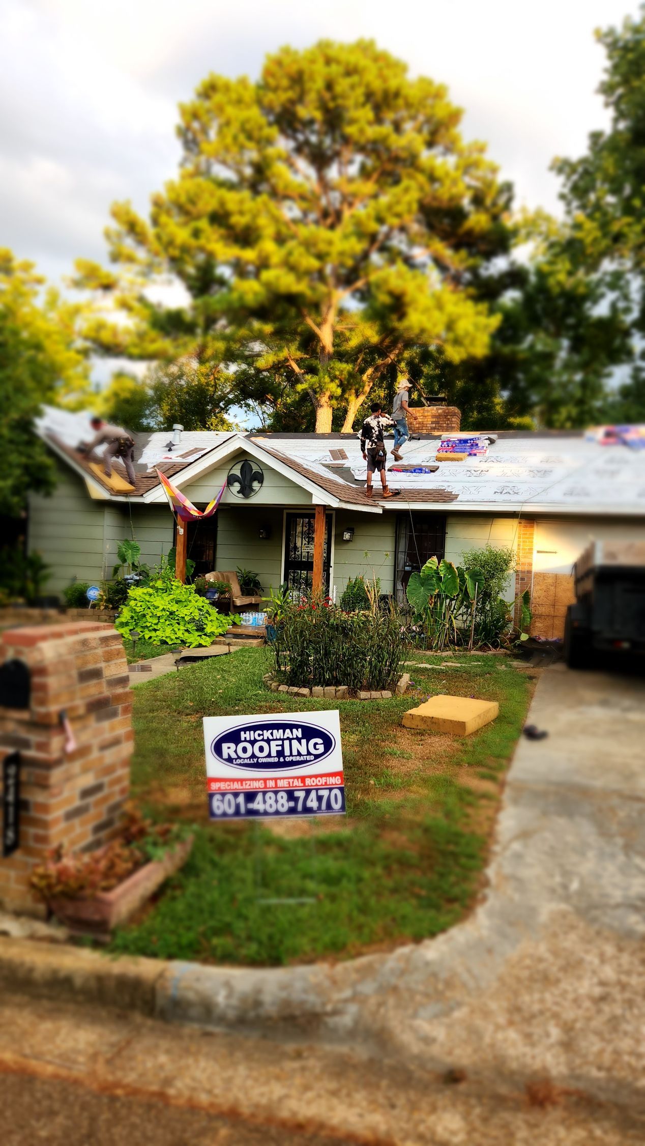A house is being remodeled with a sign in front of it.