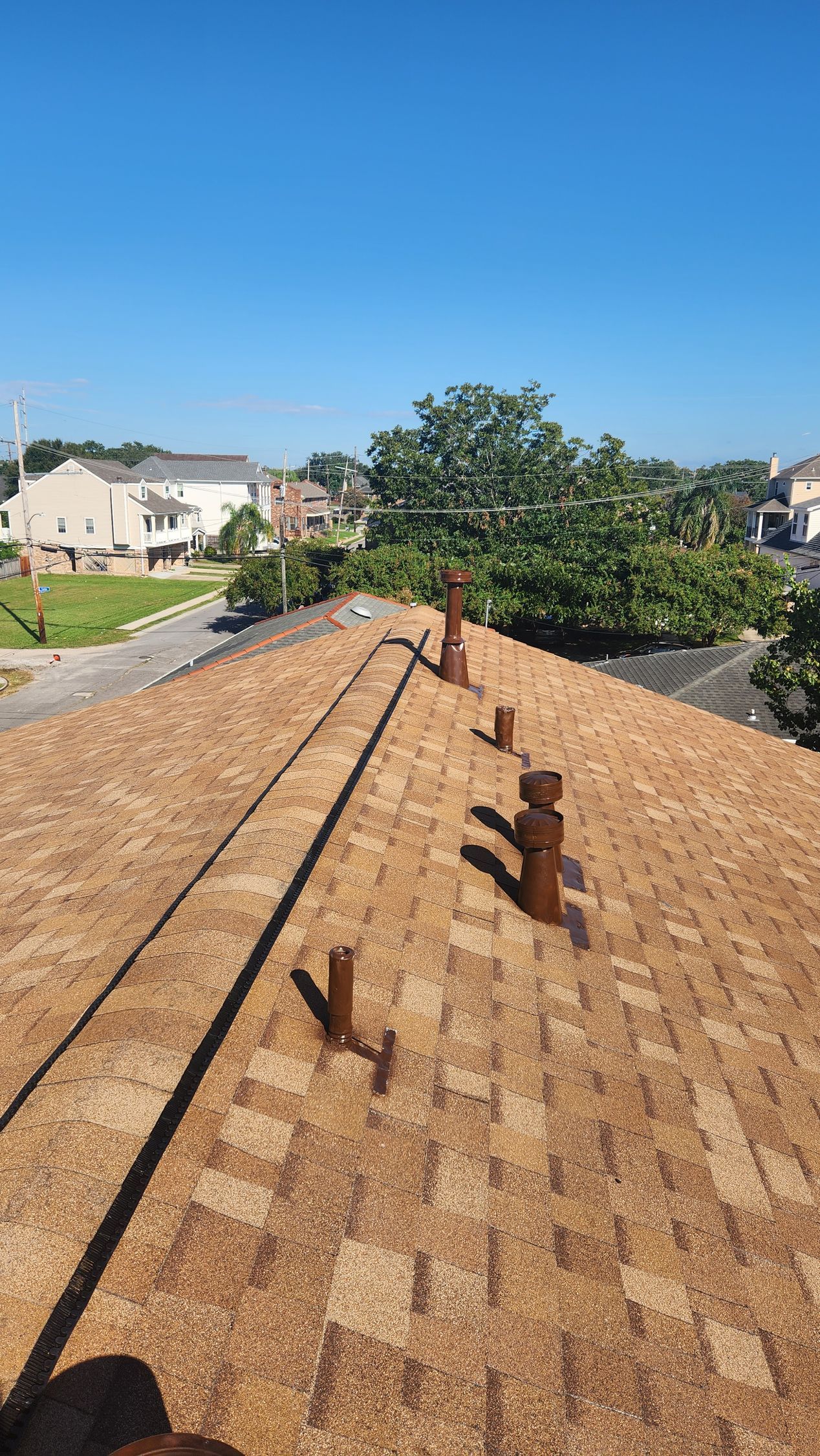 A roof with a lot of chimneys on it and a blue sky in the background.