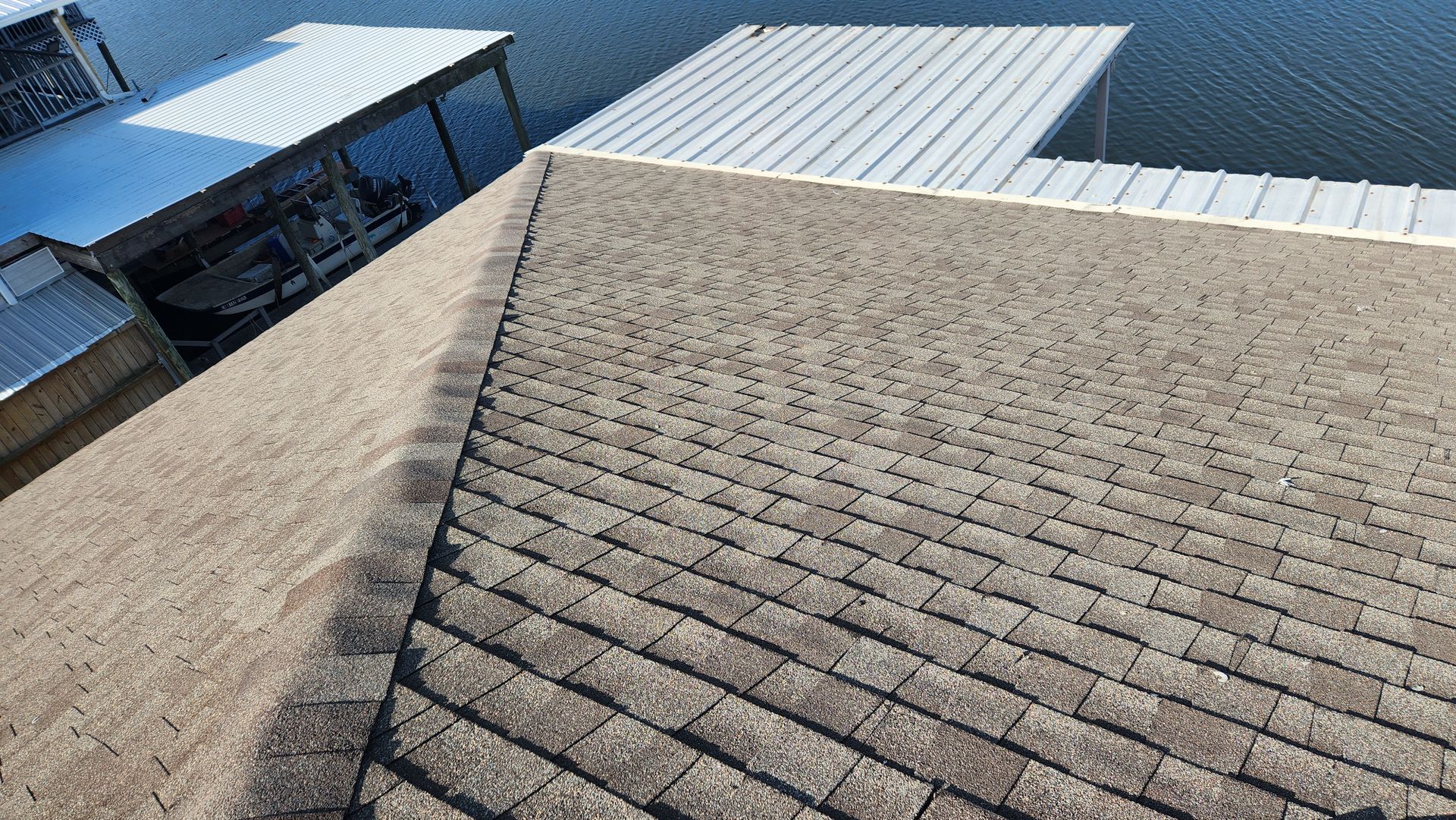 An aerial view of a roof with a dock in the background.