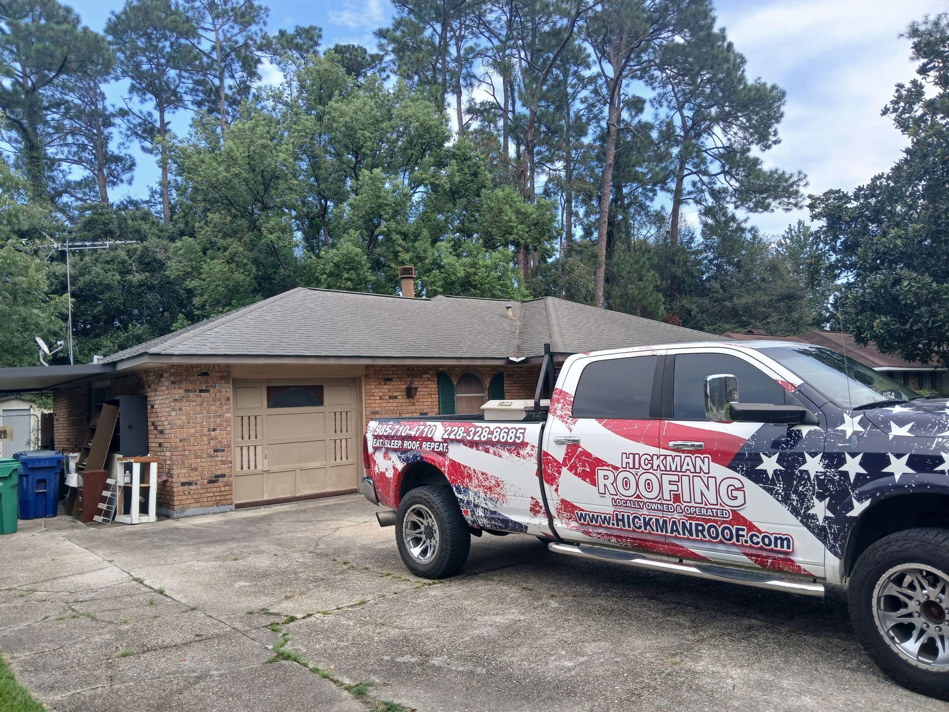 An american flag truck is parked in front of a house.