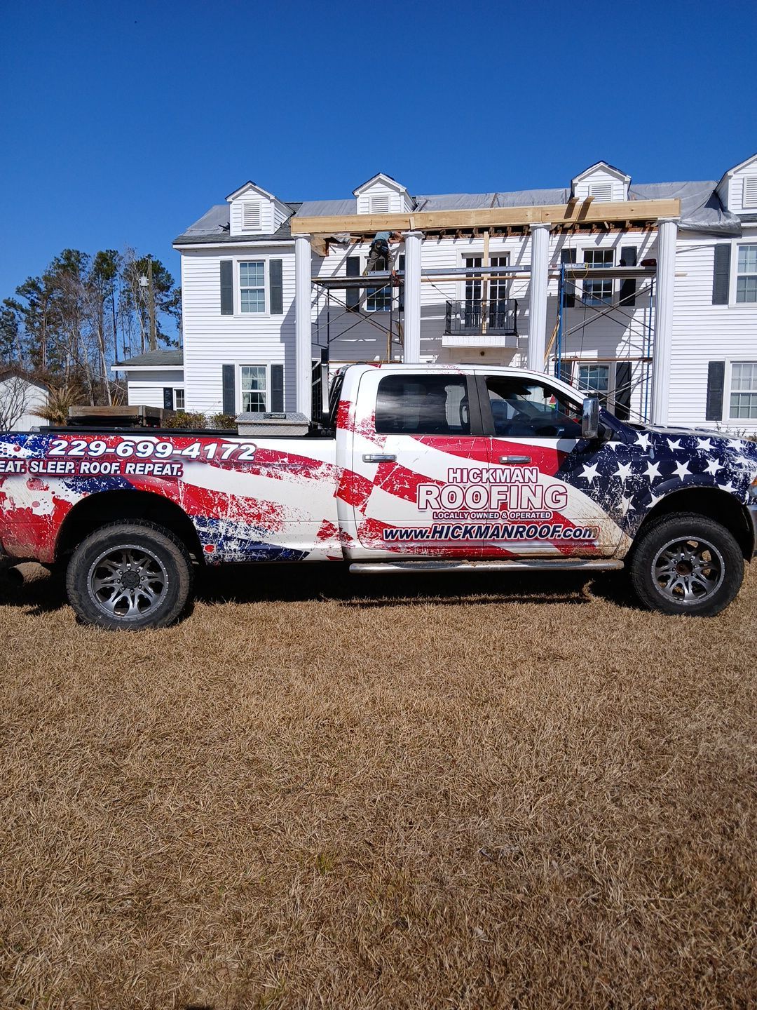 A truck is parked in front of a house under construction.