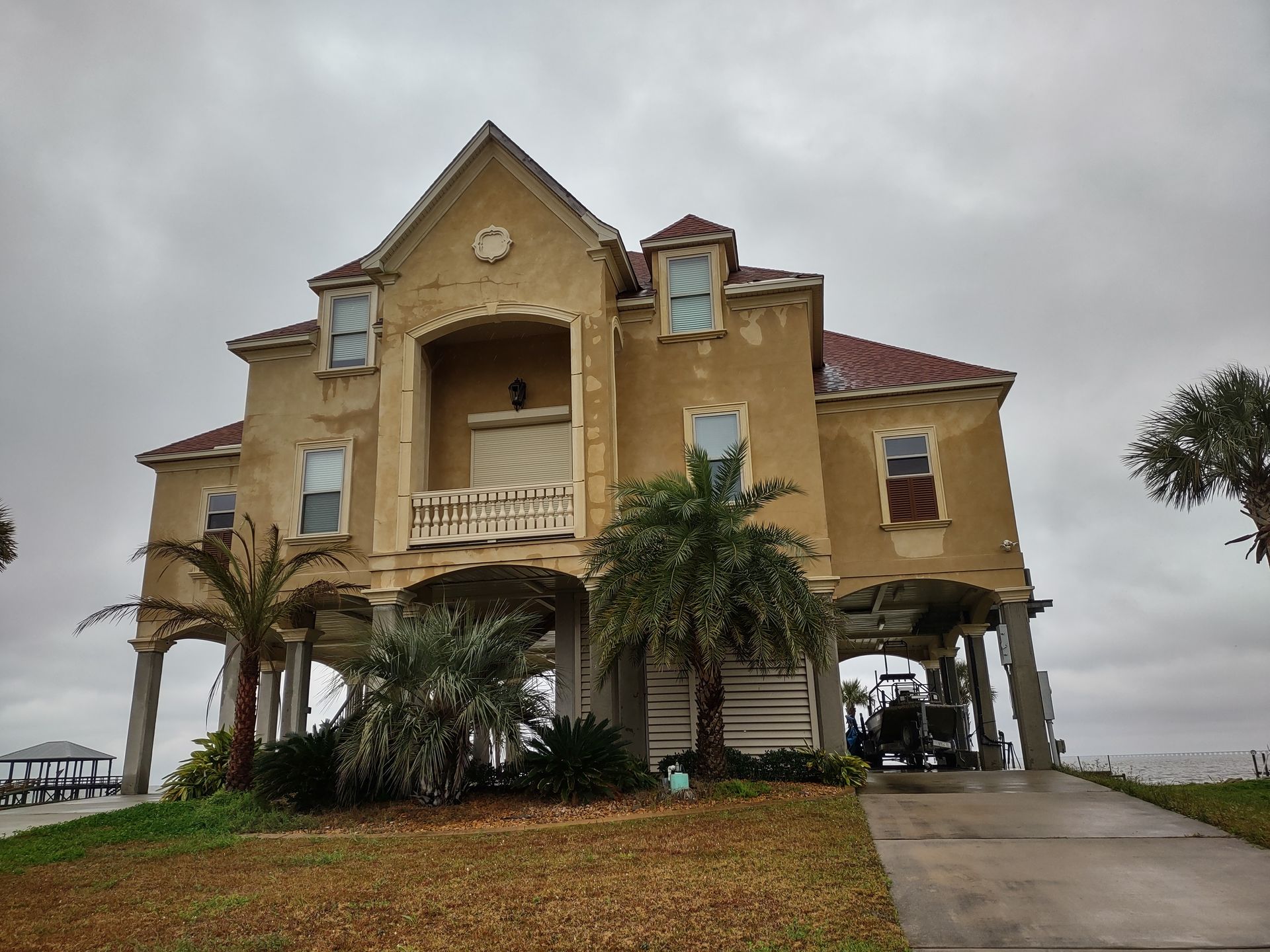 A large house with a lot of windows and palm trees in front of it.