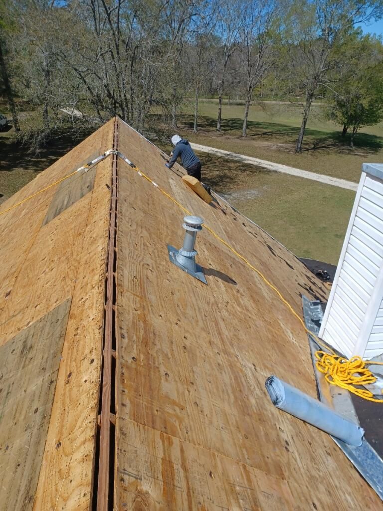 A man is working on the roof of a house.