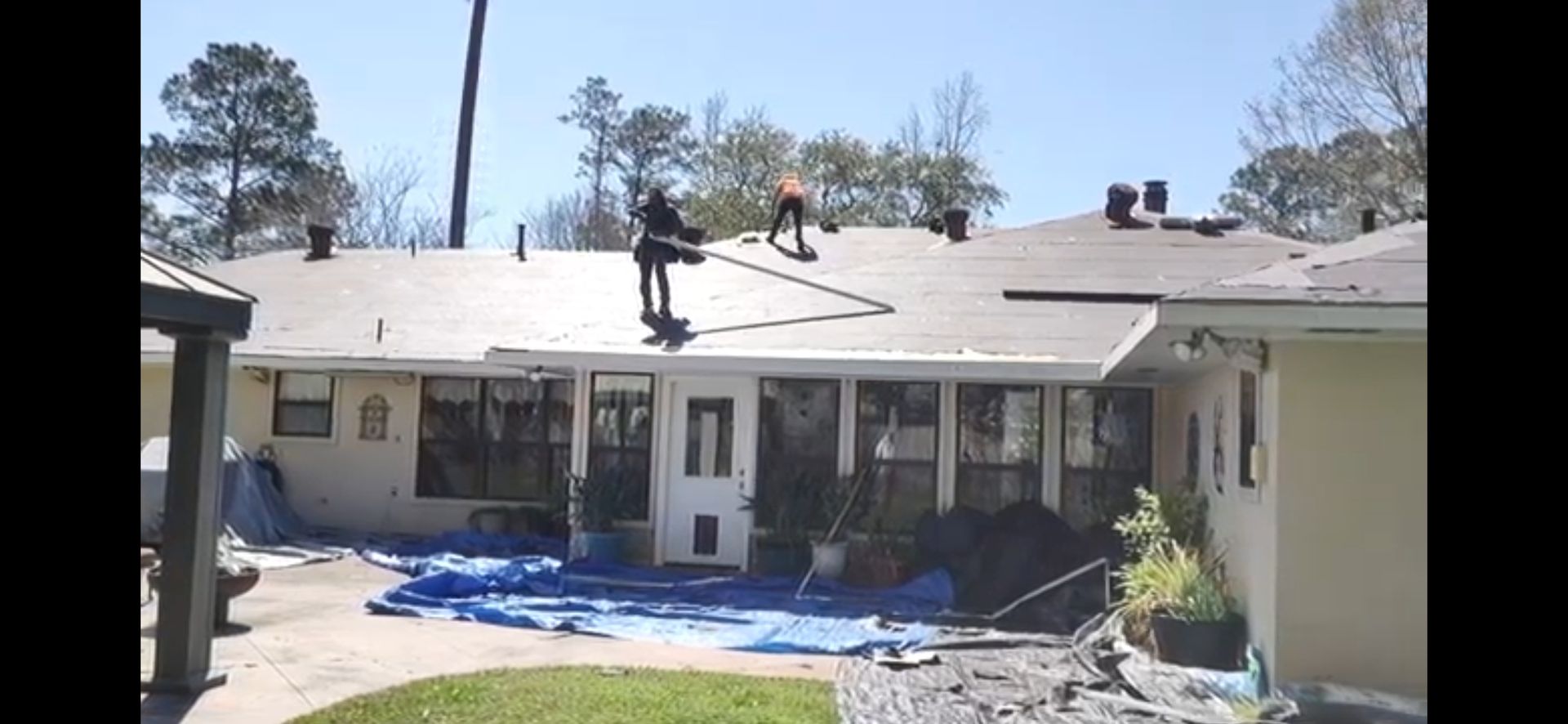 A man is standing on the roof of a house.
