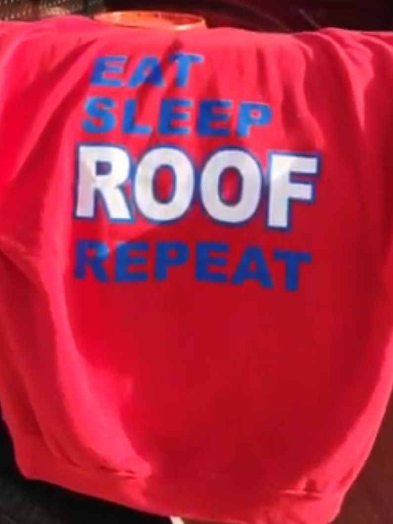 A red shirt that says eat sleep roof repeat