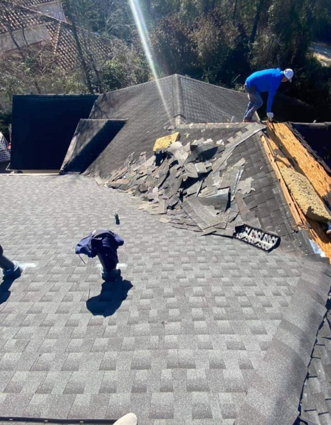 A man is working on the roof of a house.