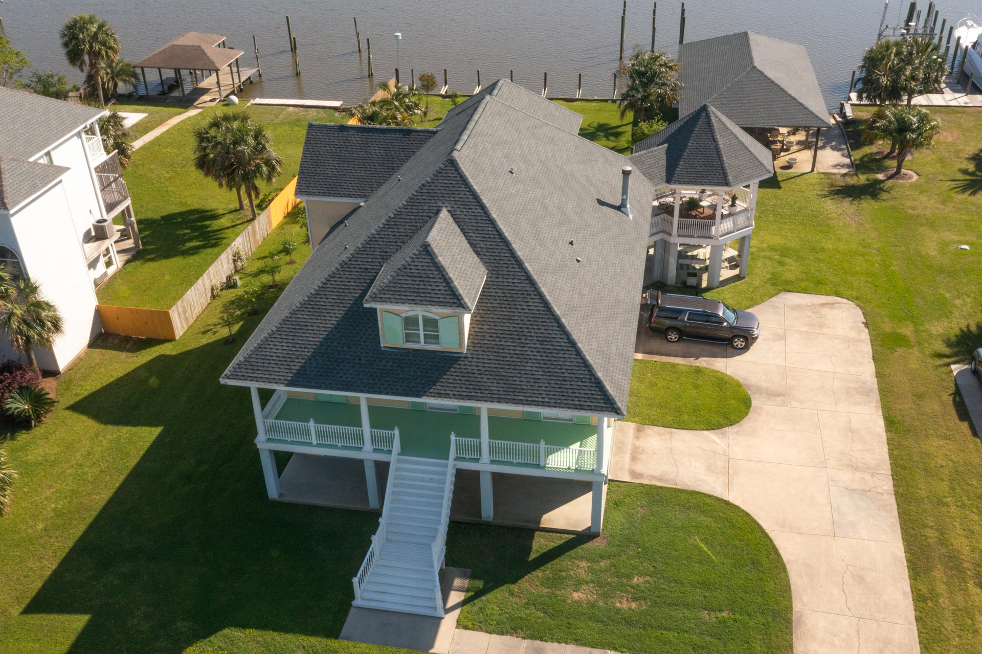 An aerial view of a house next to a body of water