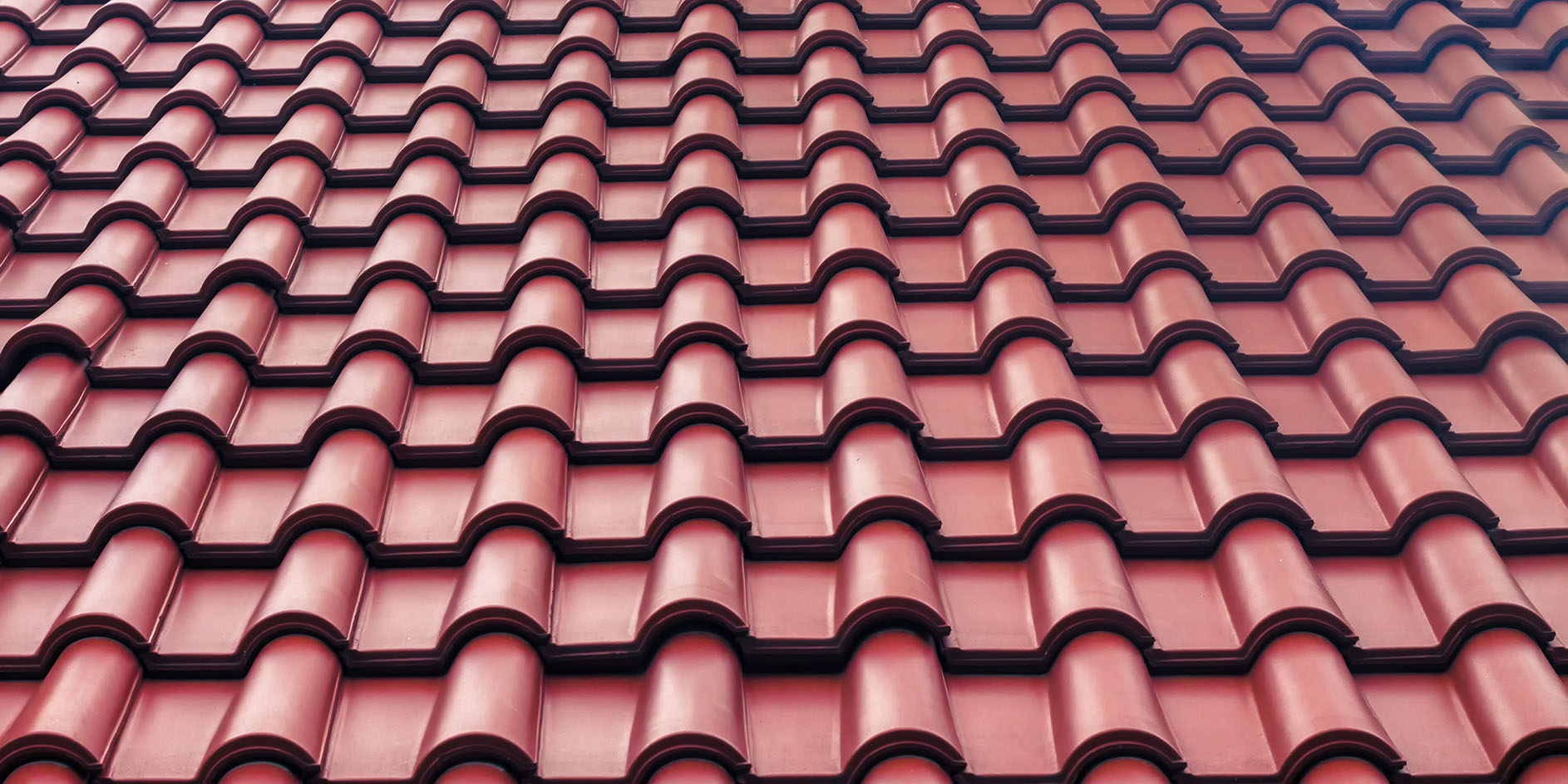 A close up of a roof with red tiles on it.