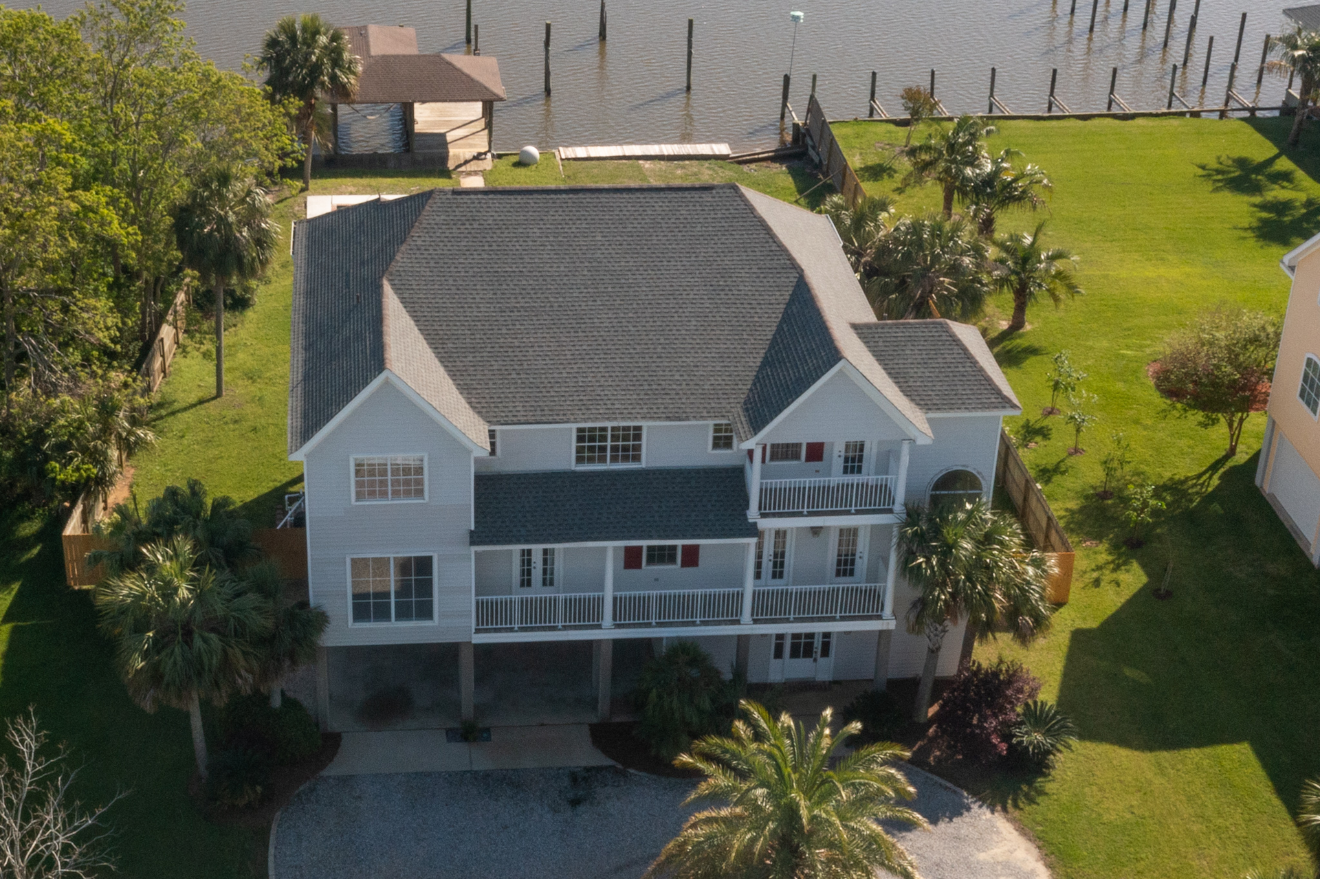 An aerial view of a house next to a body of water