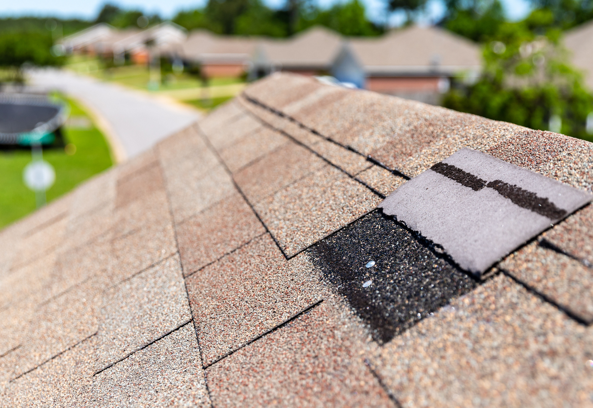 A close up of a roof with a broken shingle.