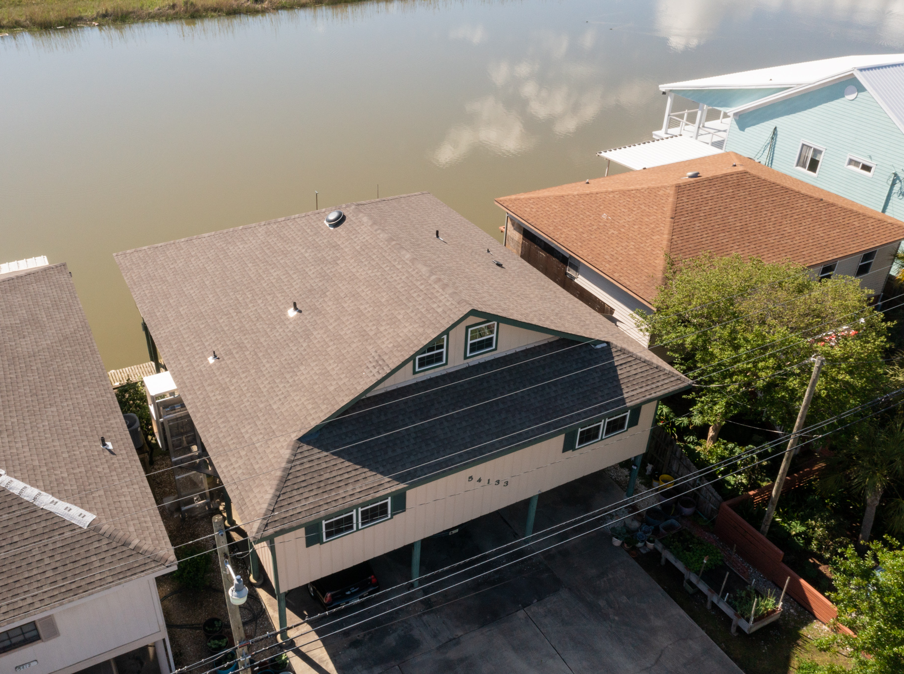 An aerial view of a house next to a body of water.