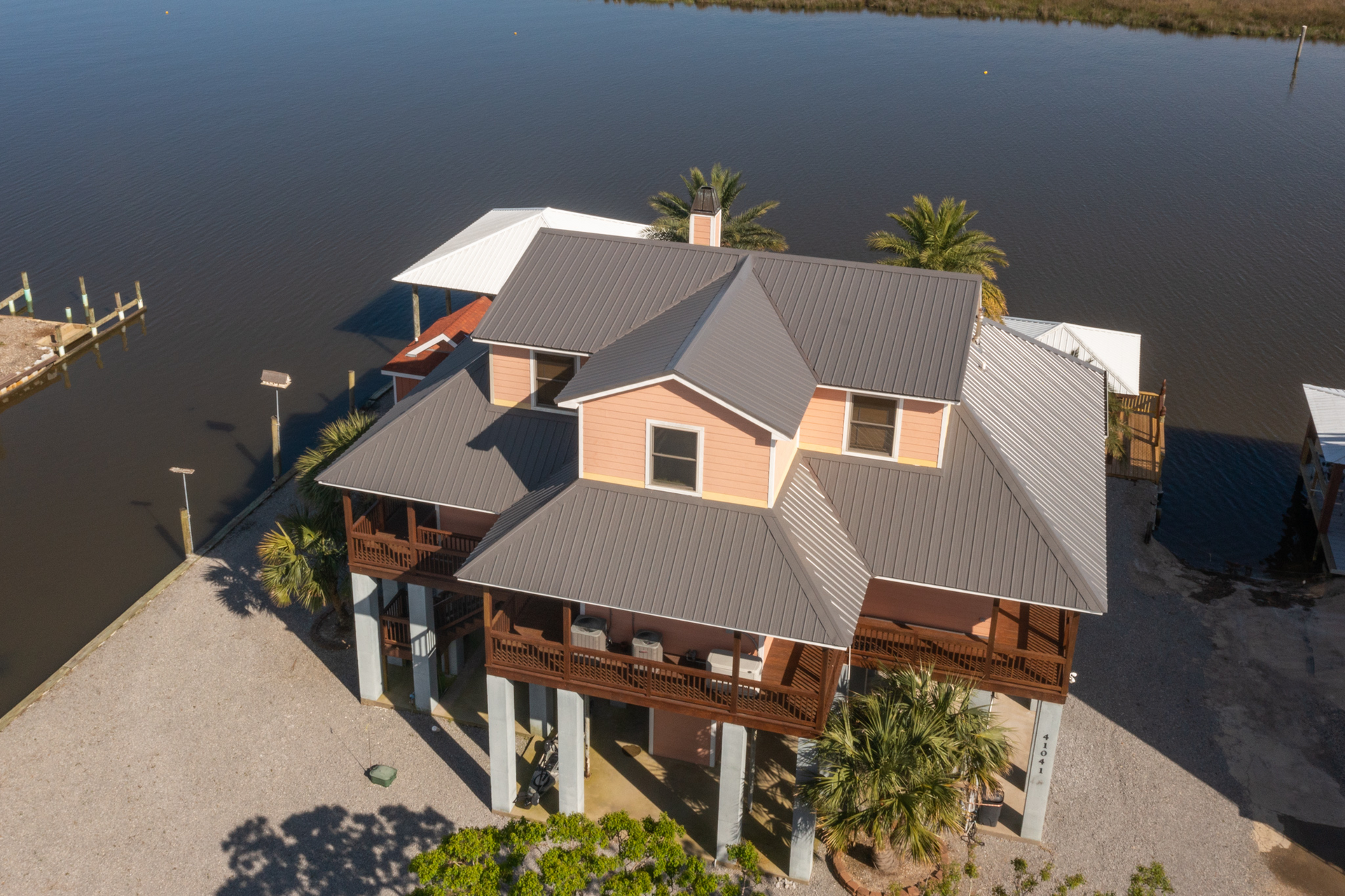 An aerial view of a house on stilts next to a body of water.