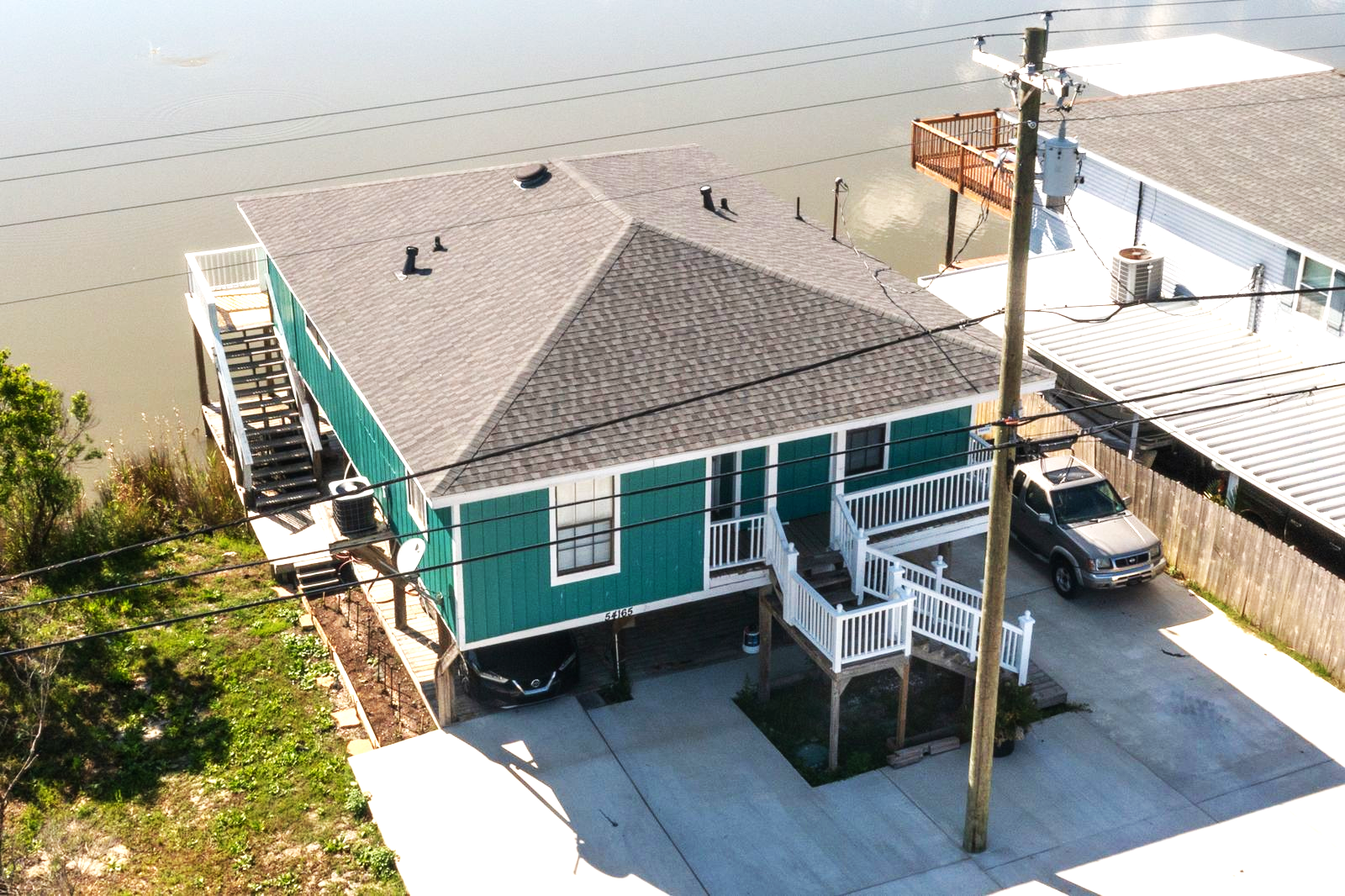 An aerial view of a green house next to a body of water.