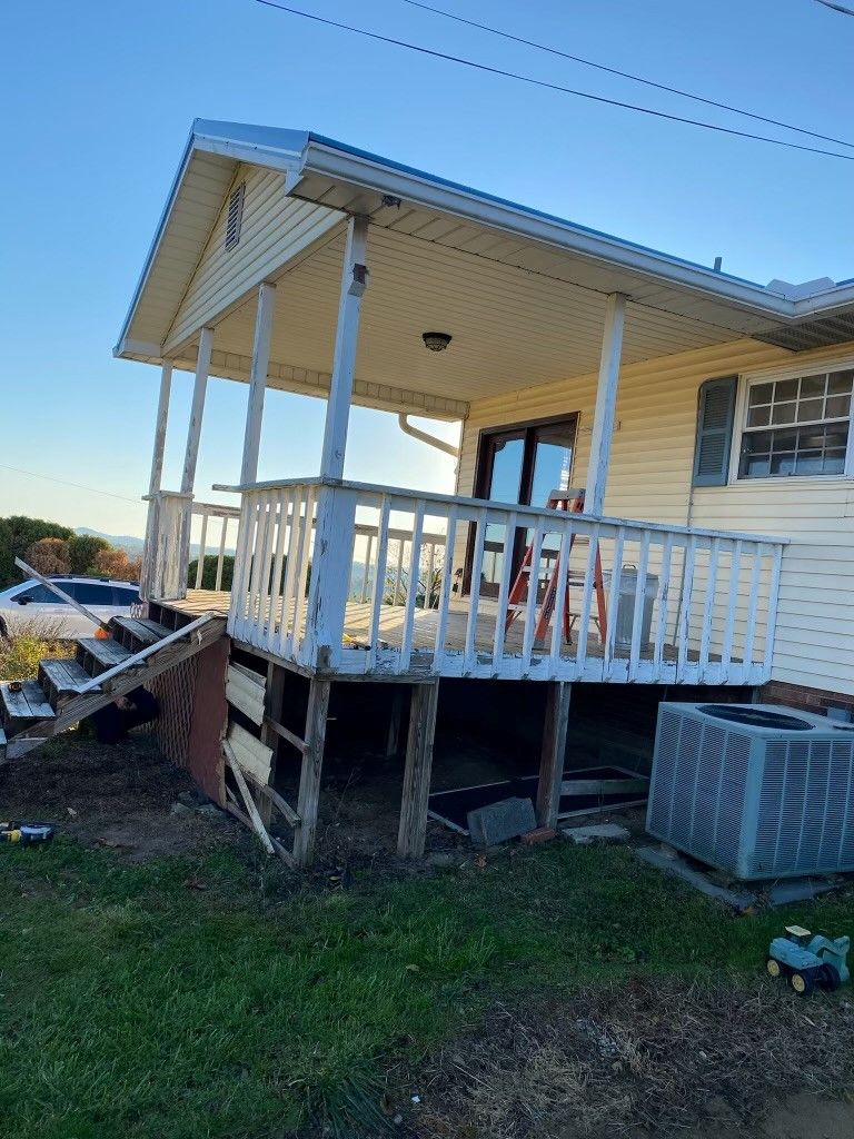 A white house with a porch and a toy truck in front of it.