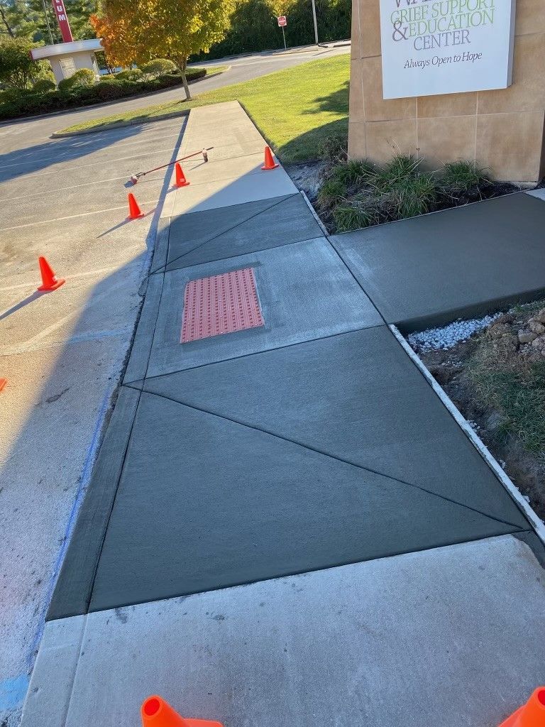 A concrete sidewalk is being built in front of a building.