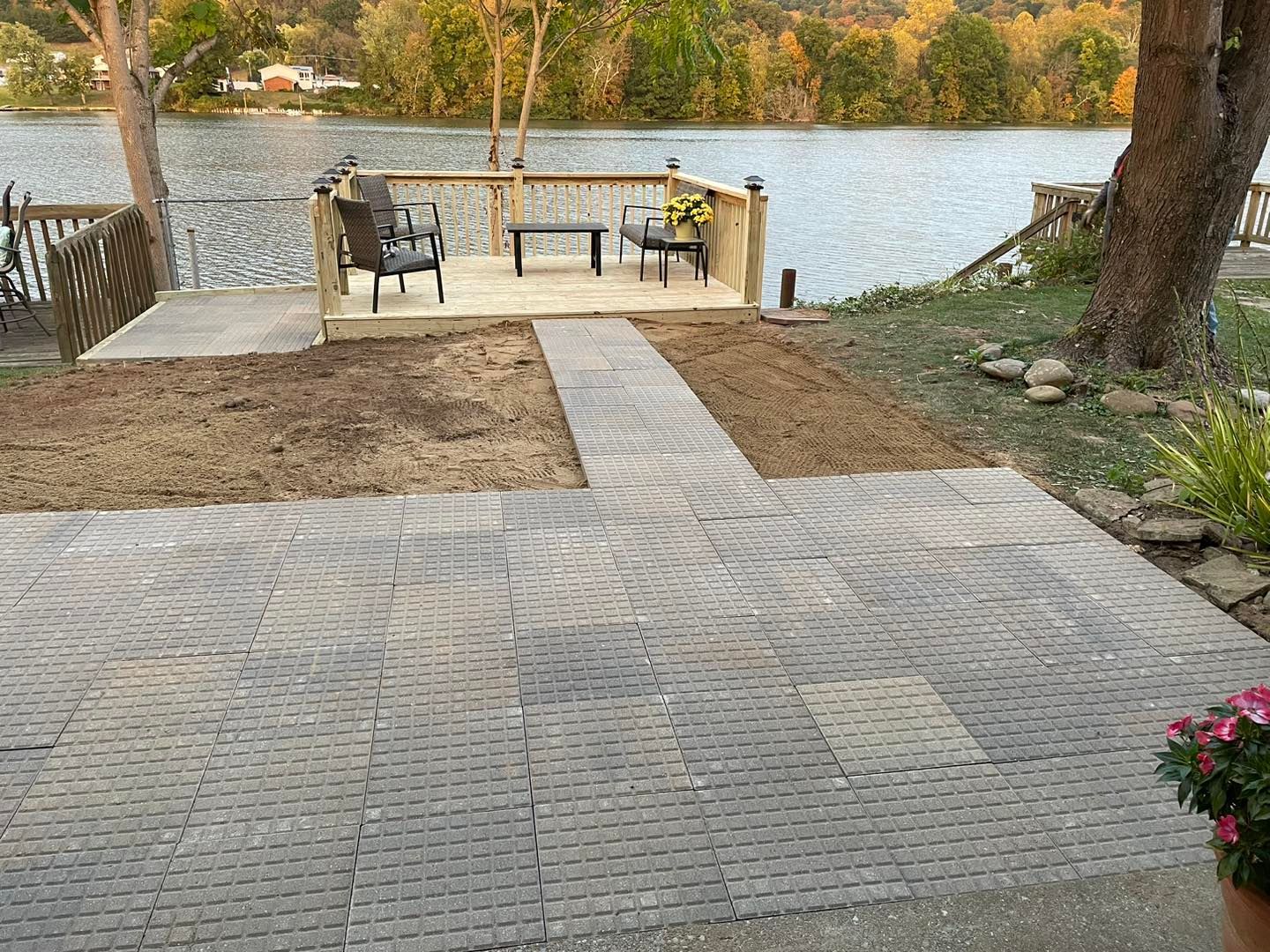 A patio with a view of a lake and a dock.