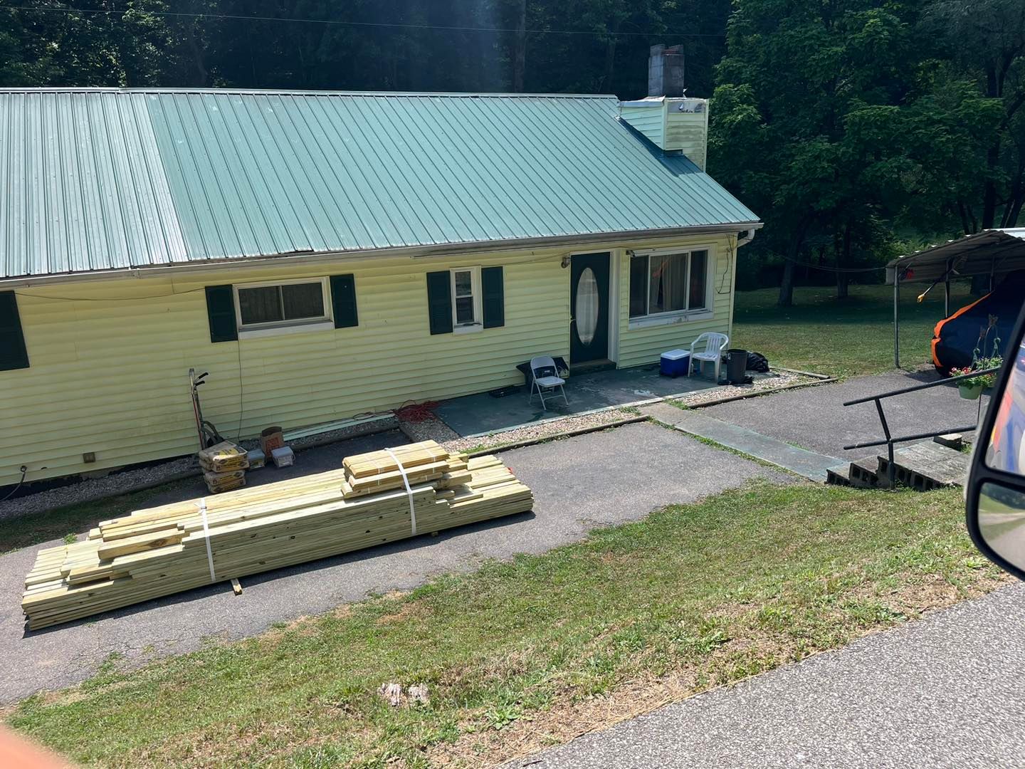 A yellow house with a green roof is being built.
