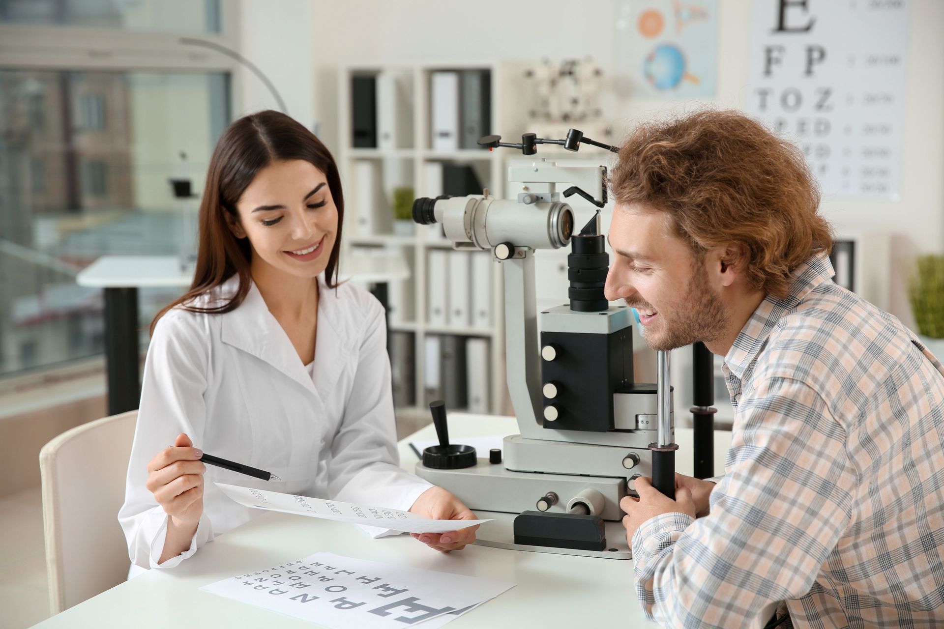 An eye examination showing an optometrist using a slit lamp to examine a patient's eyes.