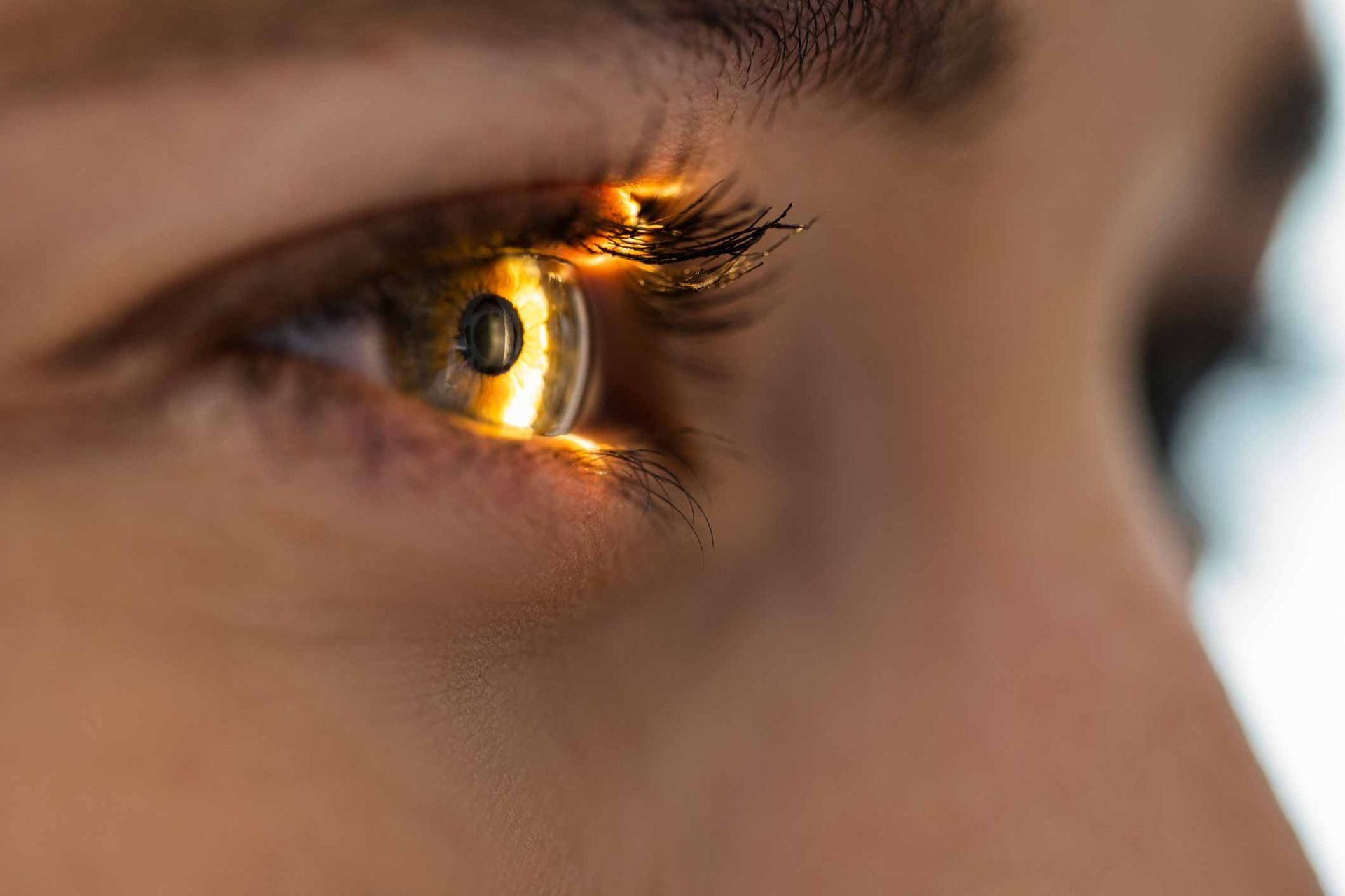 A close up of a woman 's eye with a light shining through it.