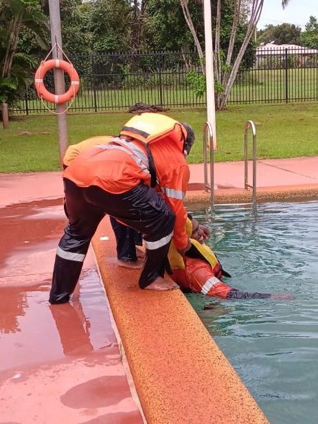 Two Men Are Standing On The Edge Of A Swimming Pool — On-Track Marine In Yorkeys Knob, QLD