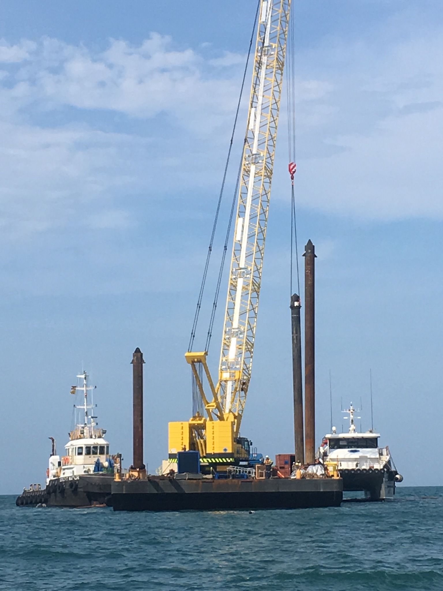 A Large Crane On Marine Vessel In Water With Two White Boats Behind— On-Track Marine In Yorkeys Knob, QLD