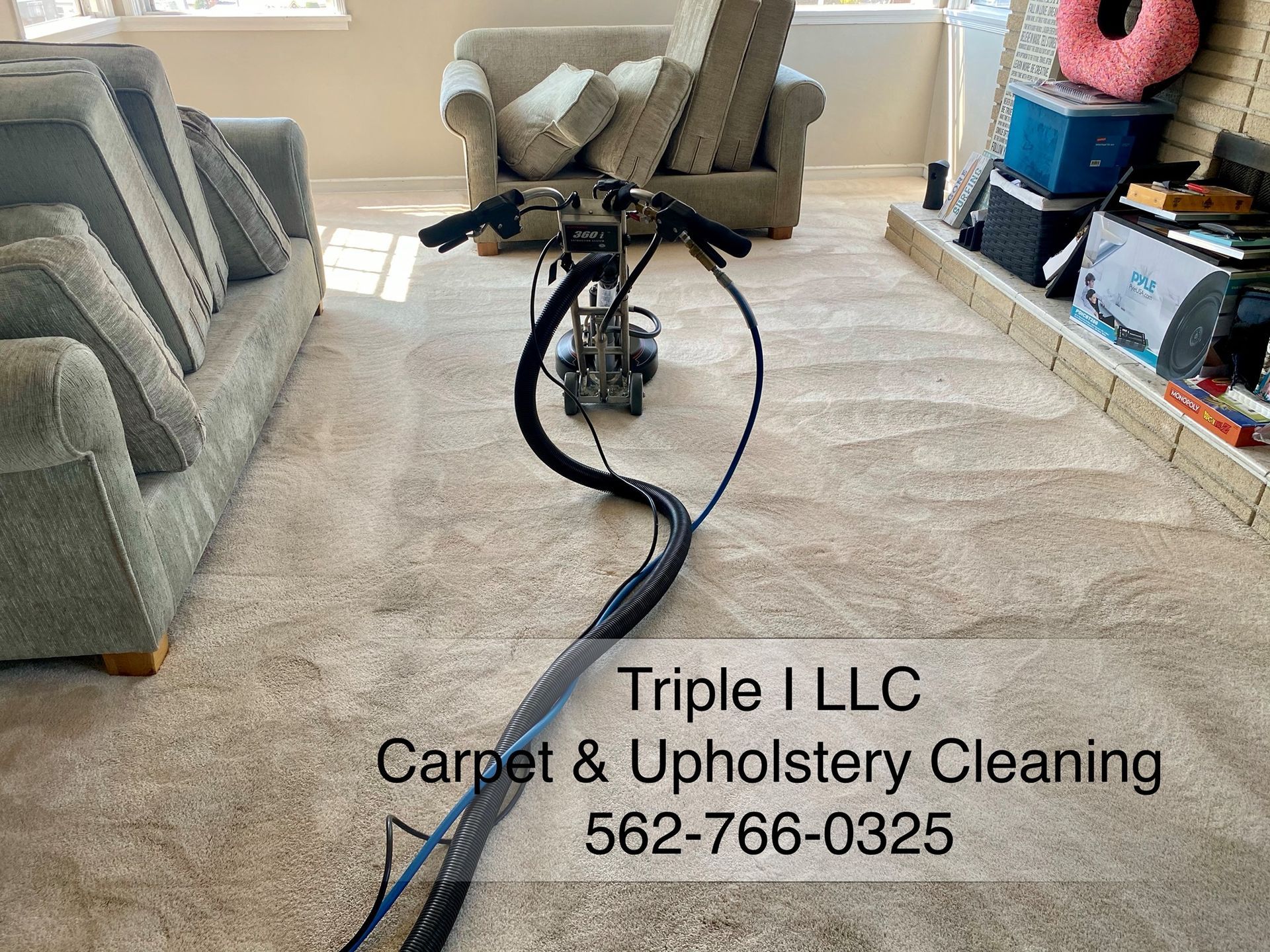 Triple I LLC | a machine is cleaning a carpet in a living room.