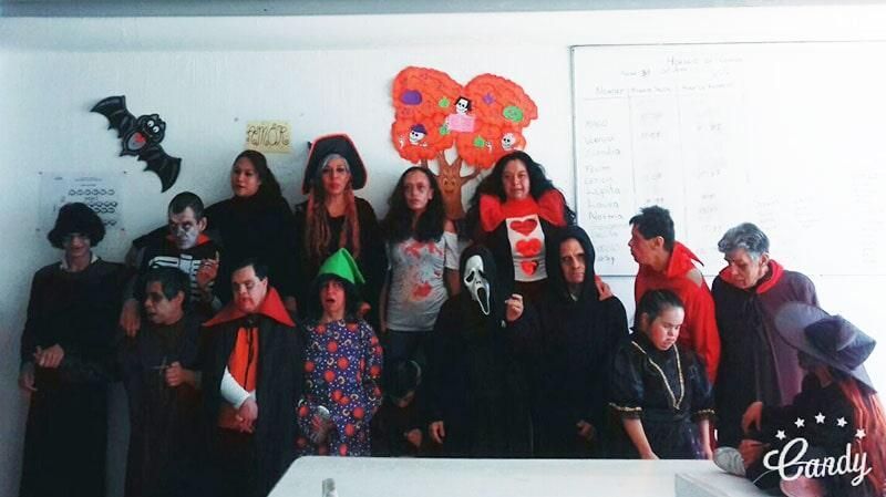 Un grupo de personas vestidas con disfraces de Halloween posan para una fotografía.
