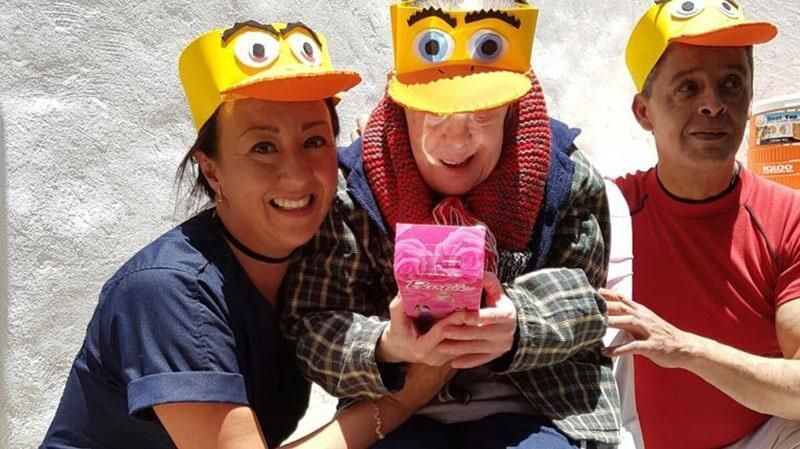 Un grupo de personas que llevan sombreros amarillos con caras en ellos.