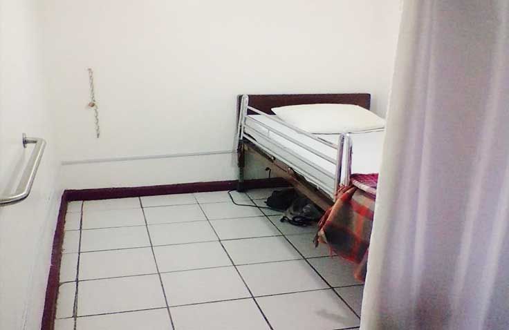 Una habitación de hospital con una cama y una cortina blanca.