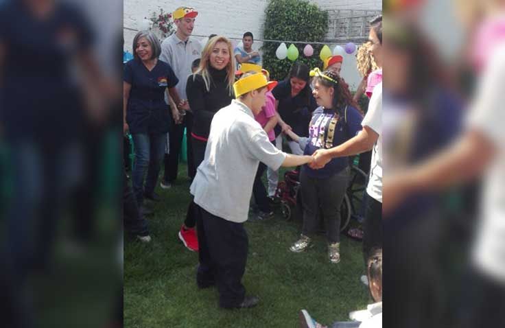 Un grupo de personas están paradas en un círculo tomadas de la mano.
