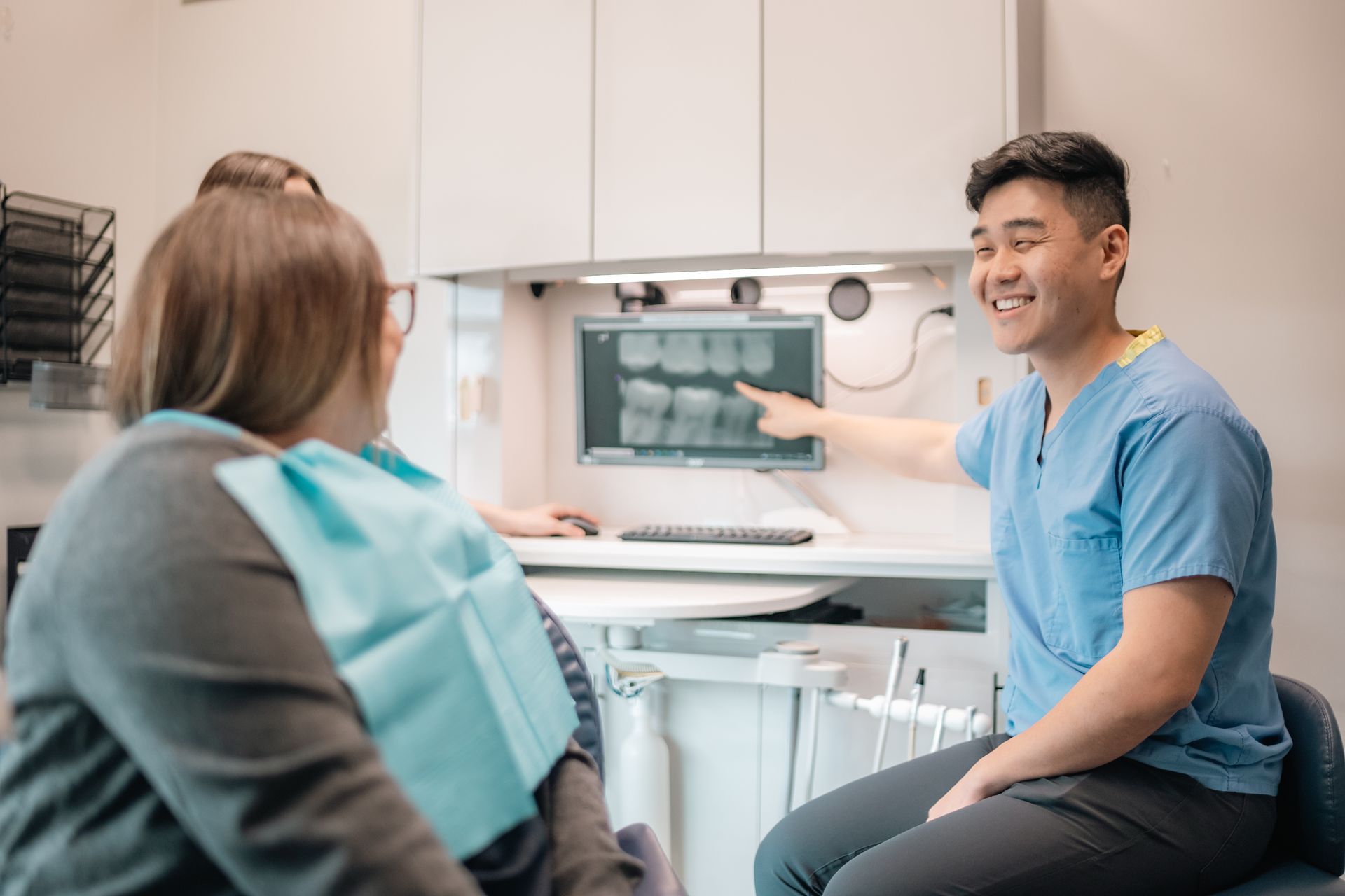 A dentist is talking to a patient in a dental office.