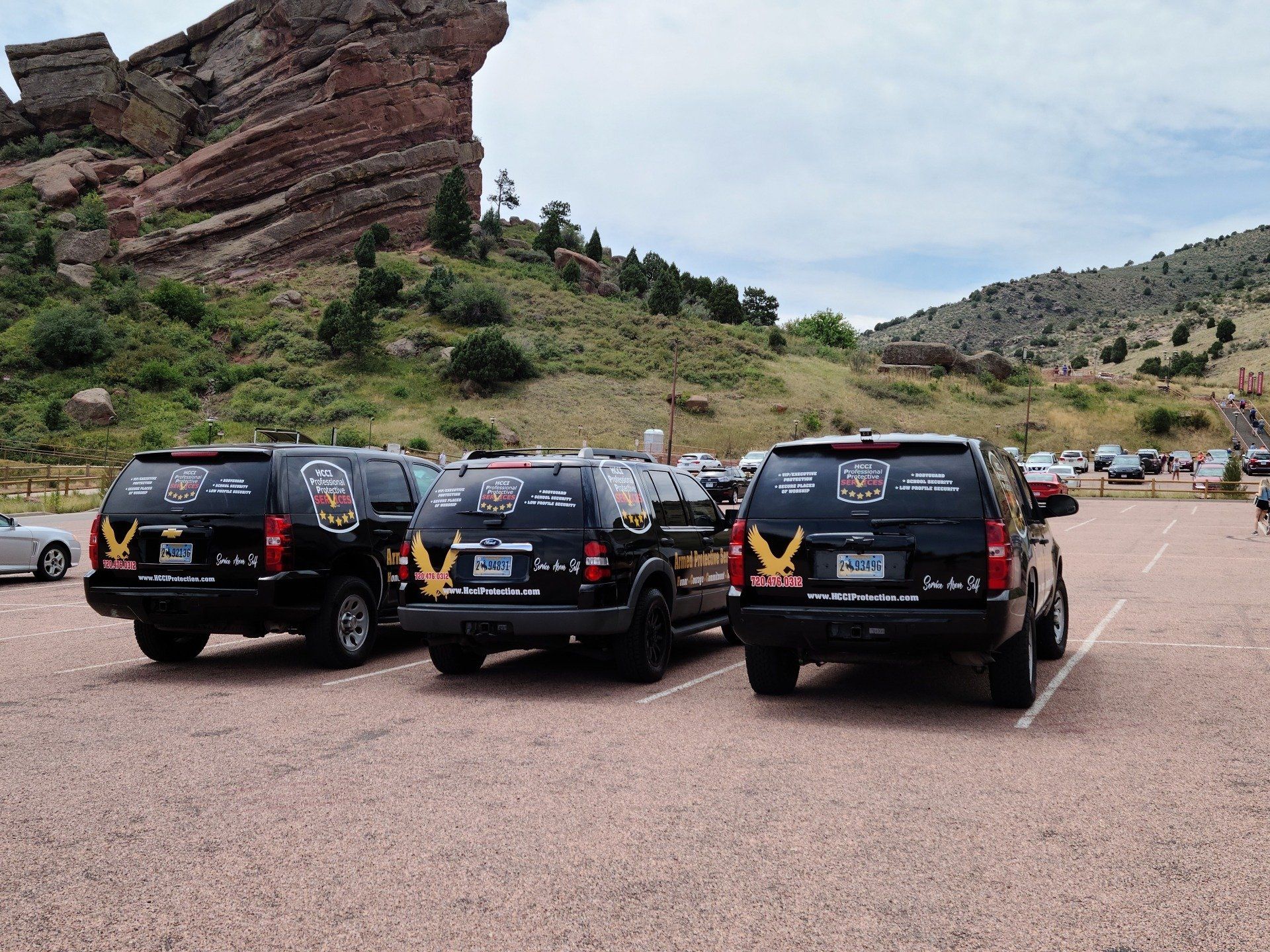 A row of police cars are parked in a parking lot