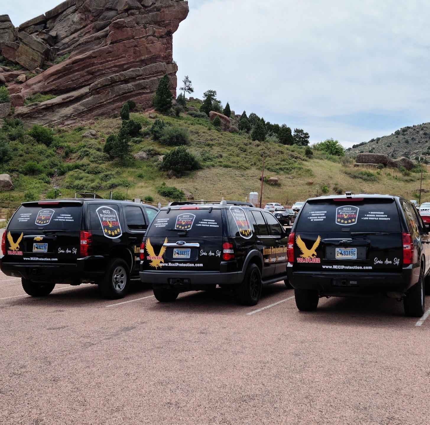 A row of cars parked in a parking lot with a mountain in the background