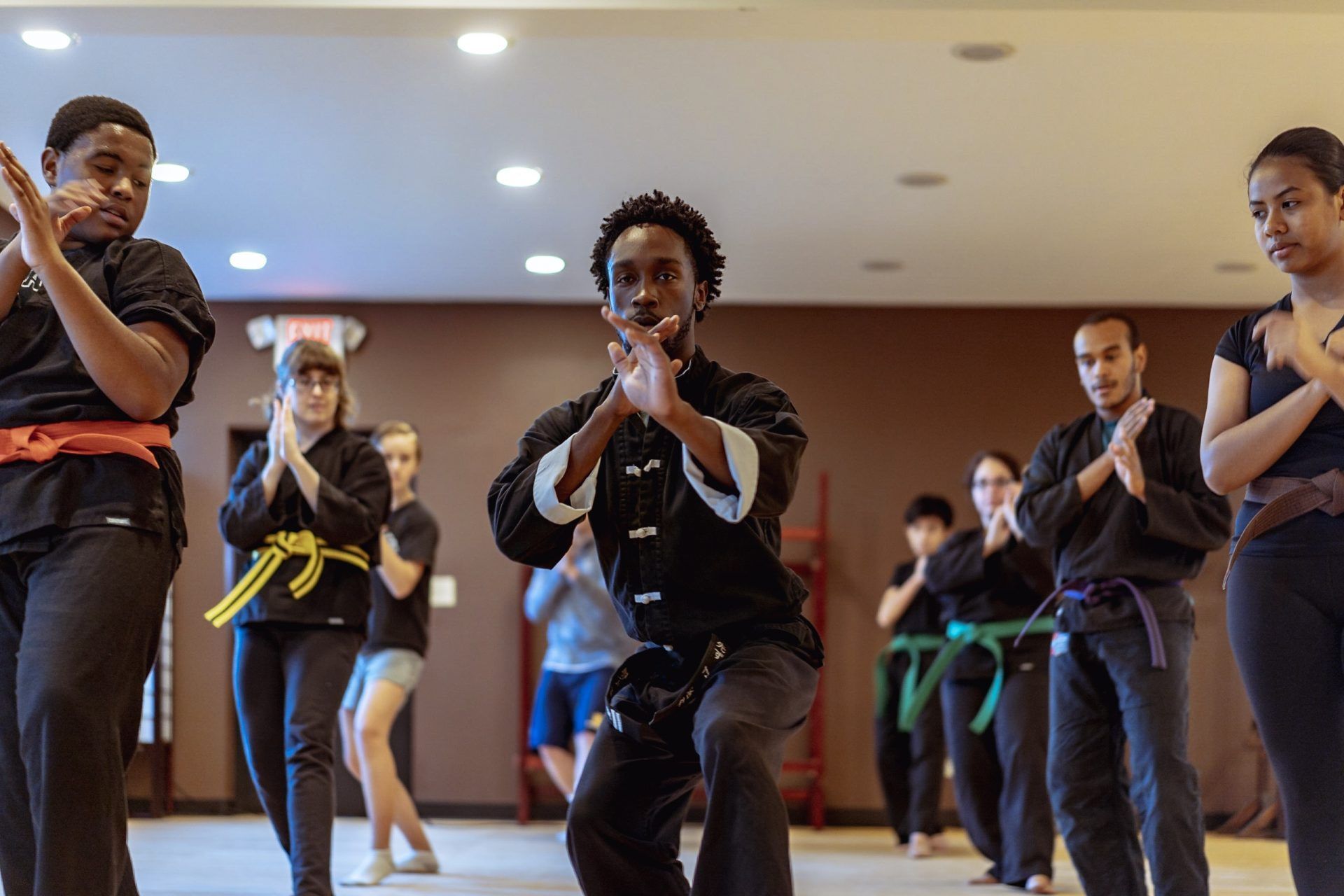 A group of people are practicing martial arts in a gym.