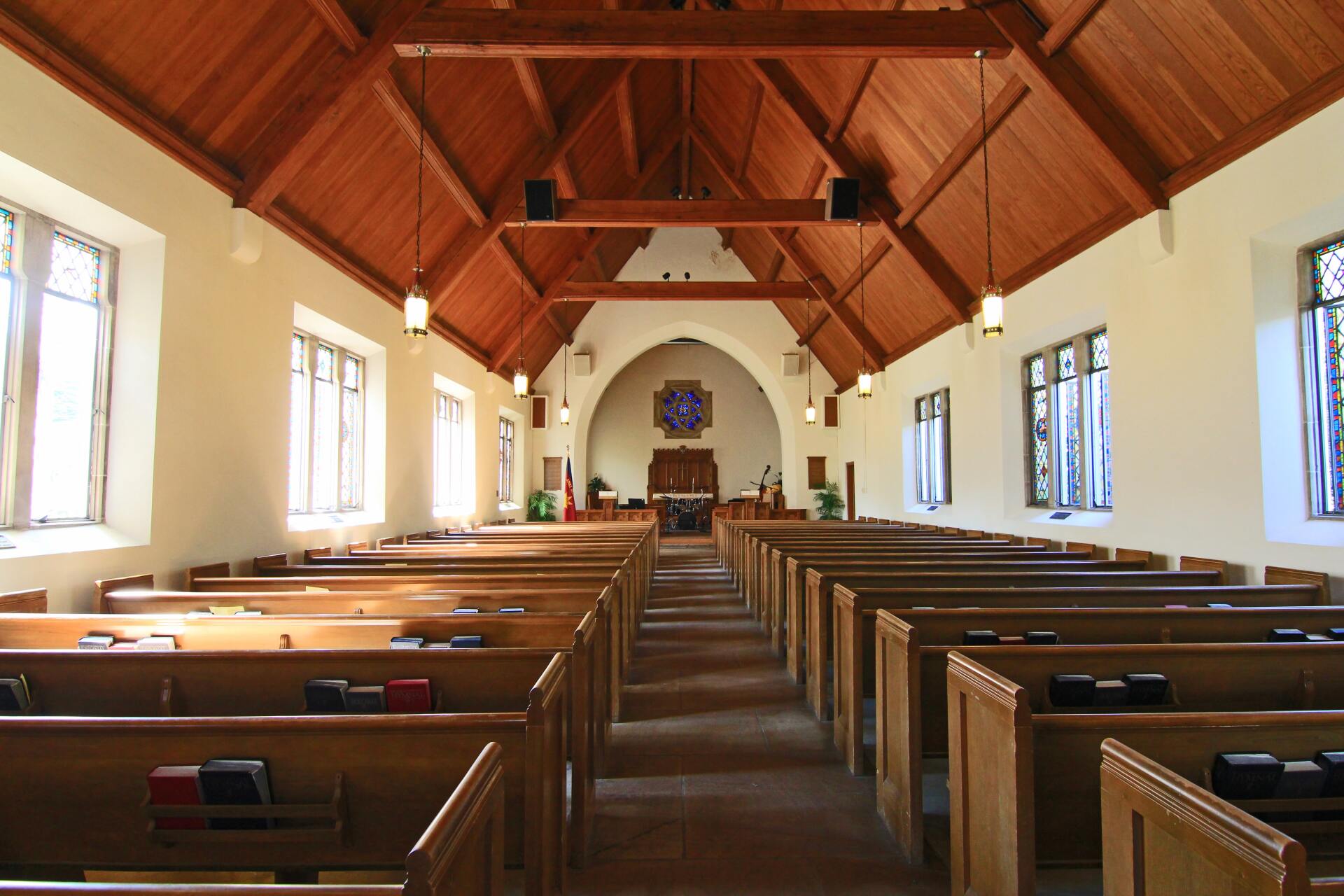 A church with rows of wooden benches and a wooden ceiling