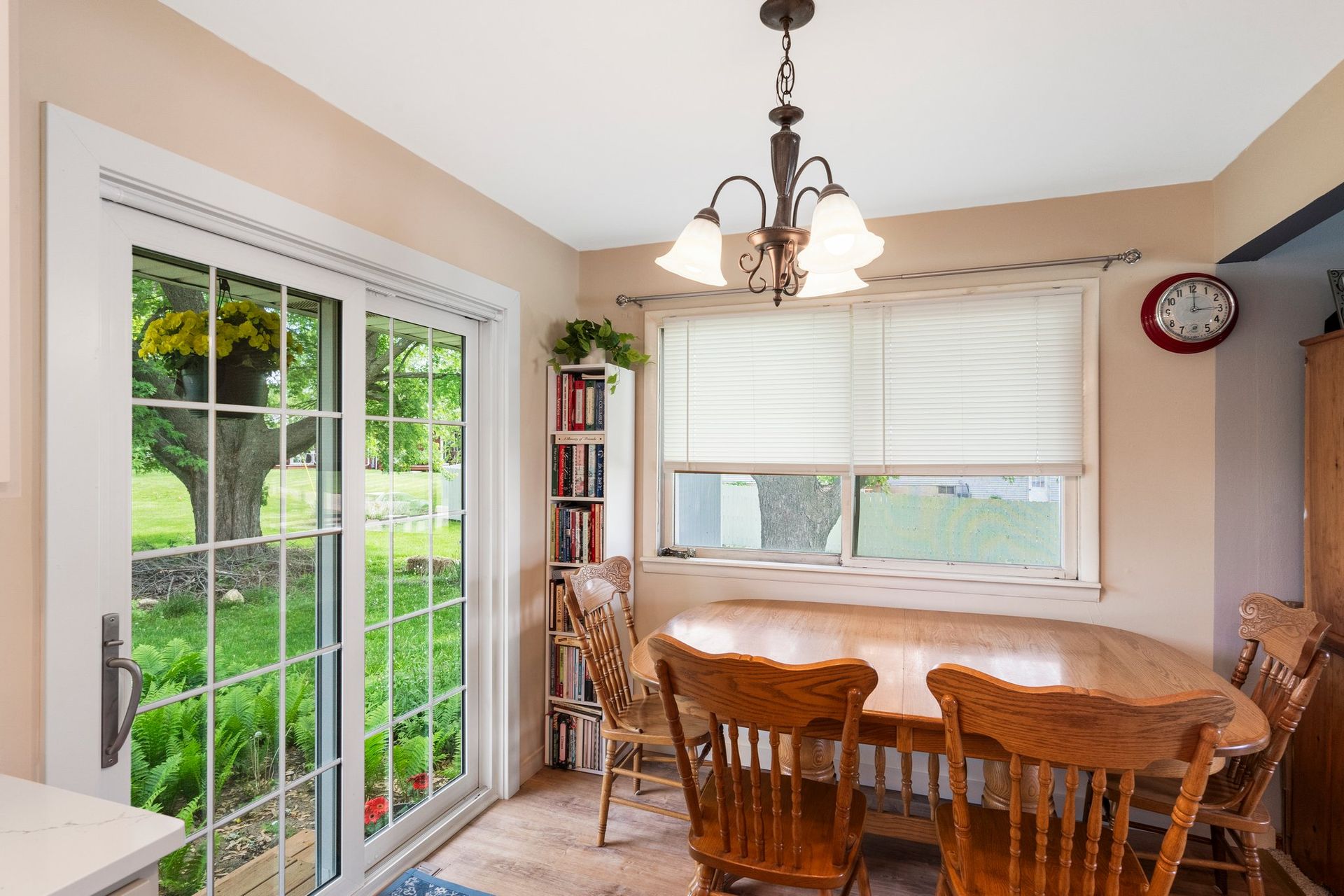 Dining area with a wooden table and chairs, sliding door to a yard, and a hanging light fixture.