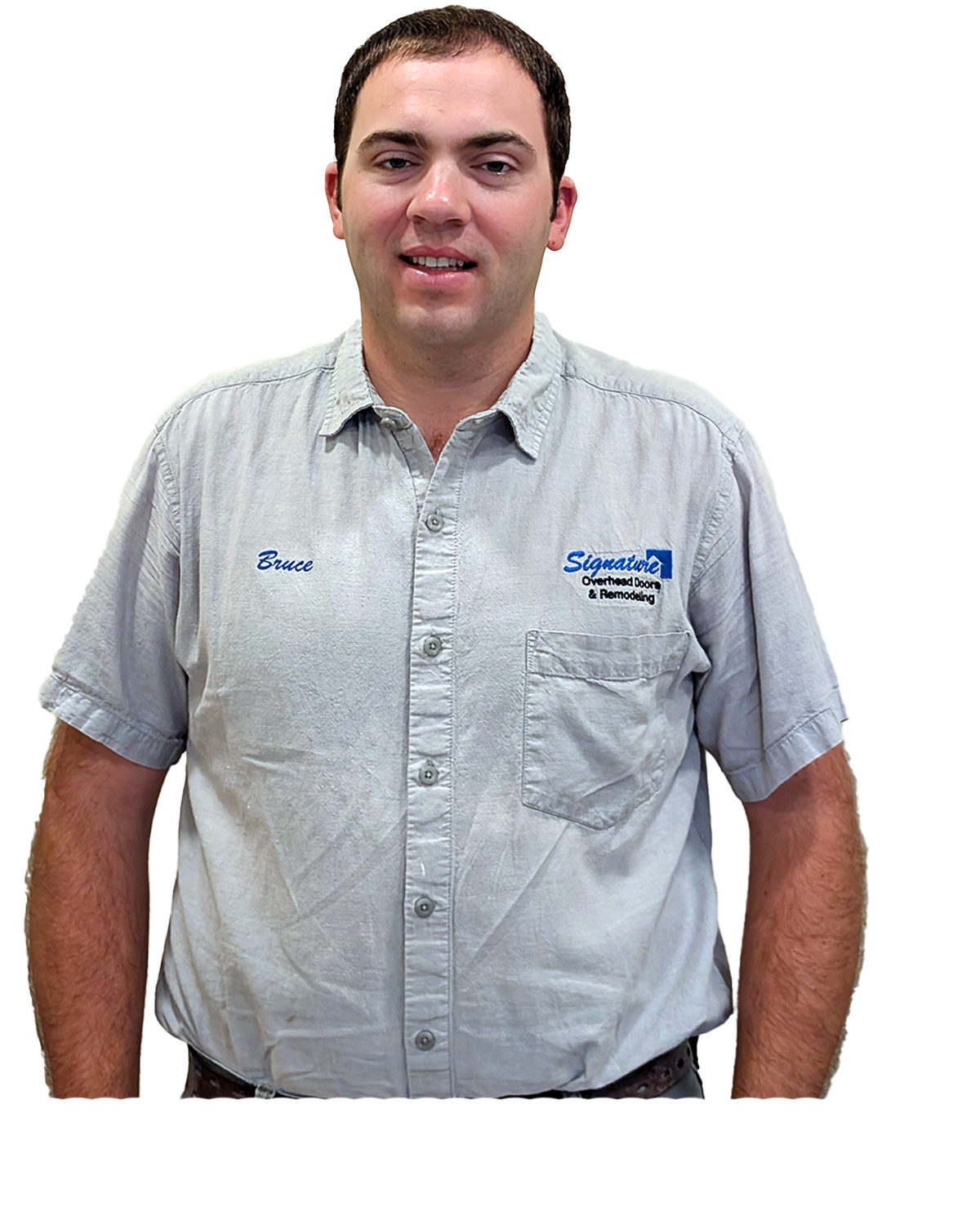 Man in a light blue uniform shirt with a logo, smiling, hands at sides.