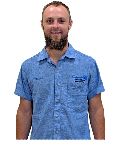 Man in a blue button-down shirt with beard smiling at the camera. A logo is visible on the shirt.