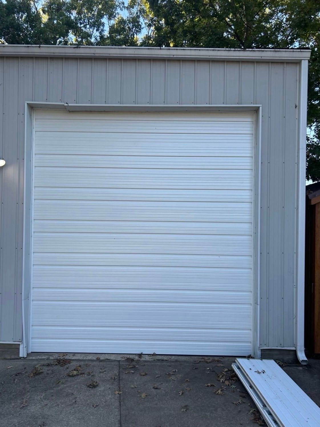 White garage door on a gray industrial building.
