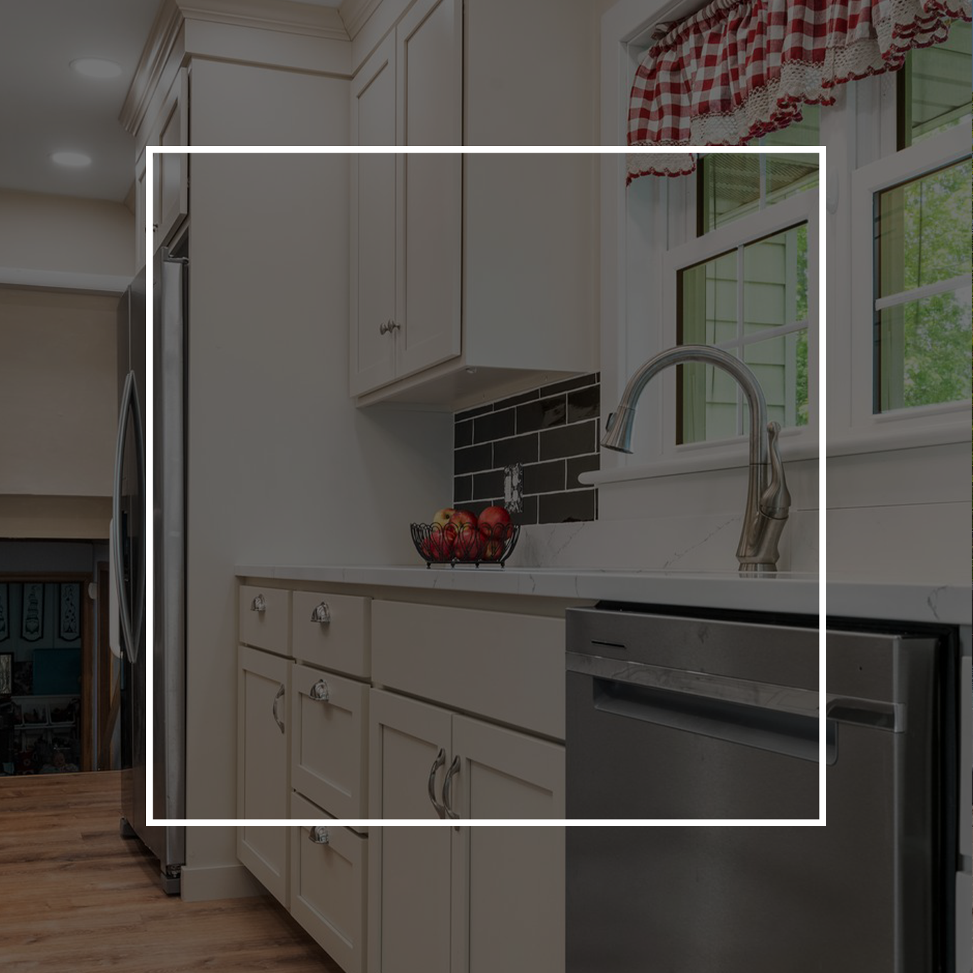 Kitchen with white cabinets, stainless steel appliances, and a red-checkered window curtain.