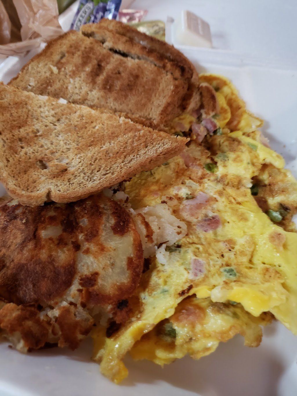 A white plate topped with a sandwich and an omelet.