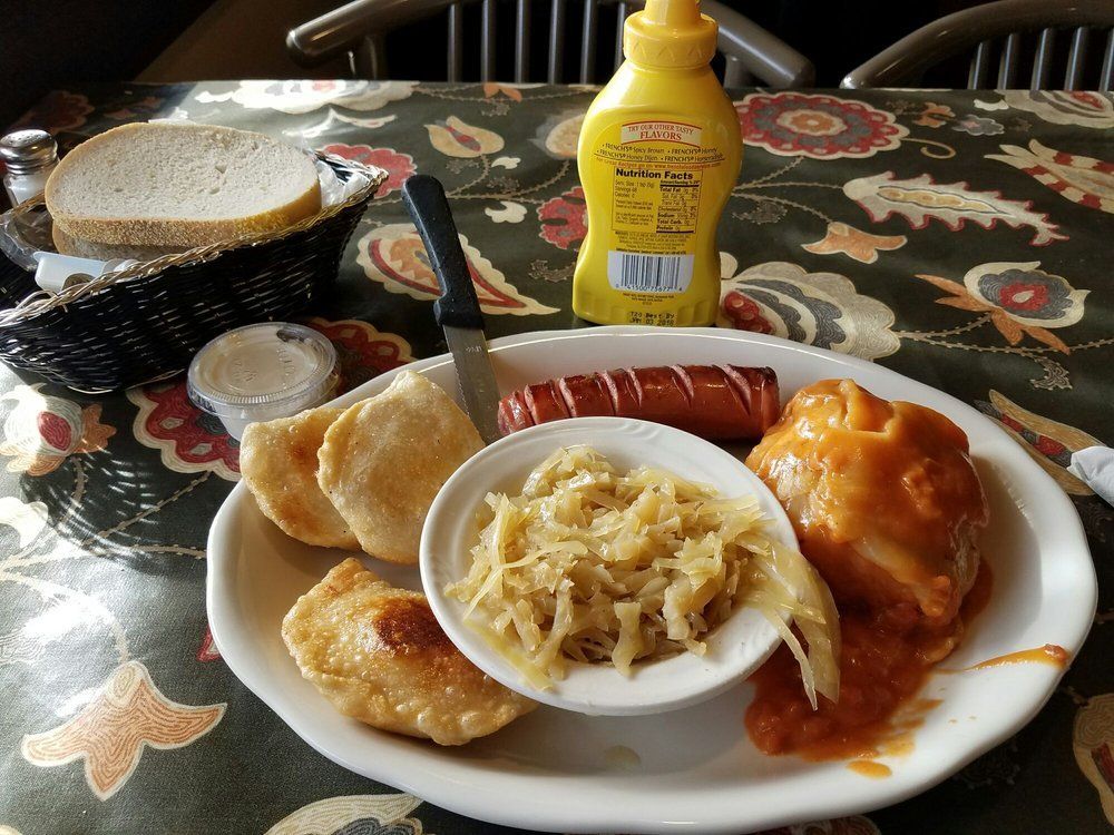 A plate of food with a bottle of mustard on the table