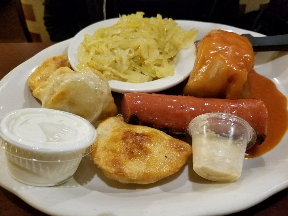 A plate of food with a hot dog and sauerkraut on it