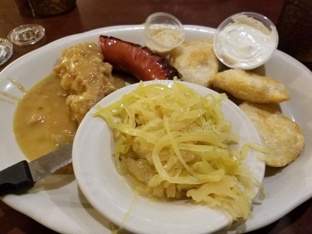 A plate of food with a sausage and sauerkraut on it